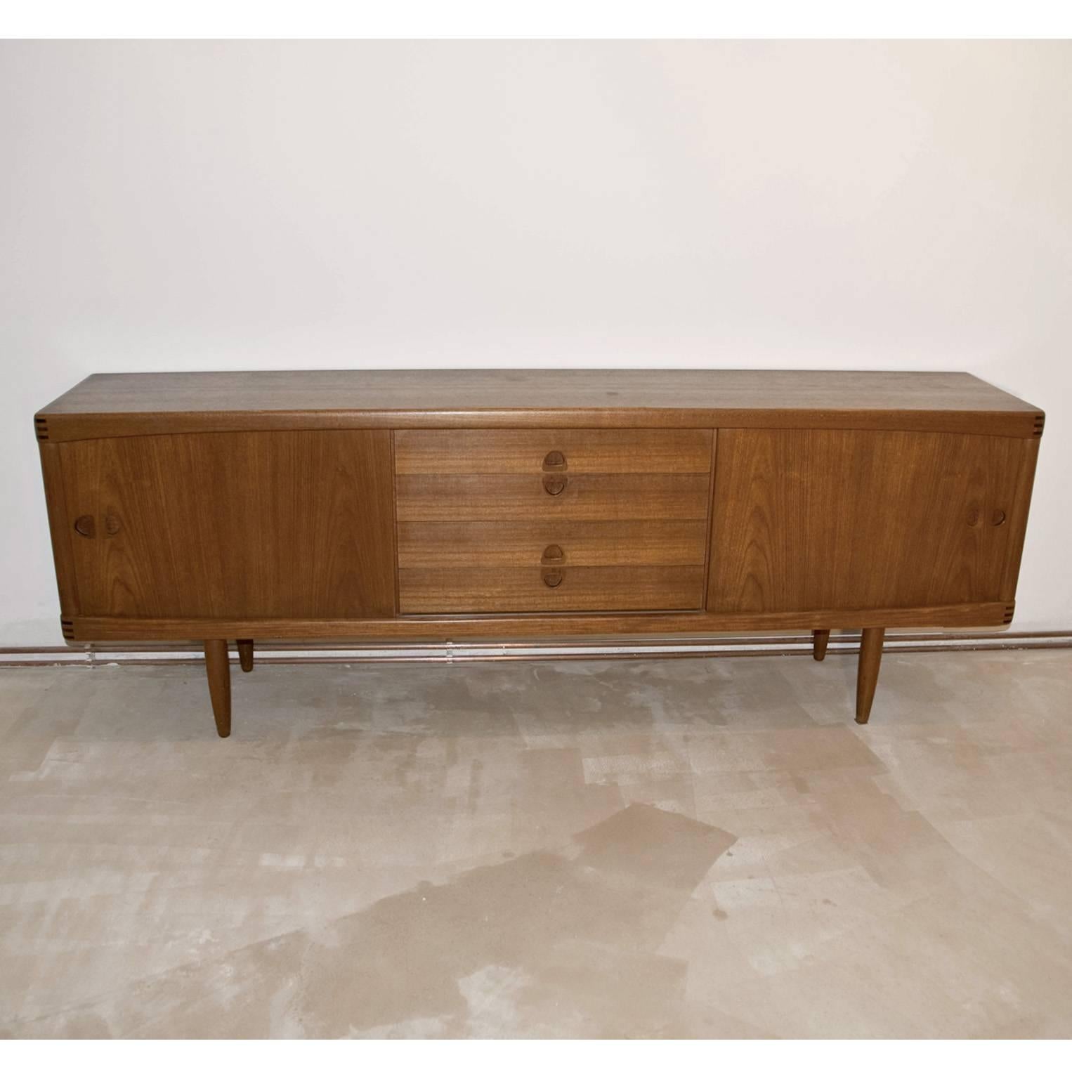 Iconic teak sideboard by H.W. Klein for Bramin, Denmark, 1960s. Two side cabinets with sliding doors and four middle drawers.