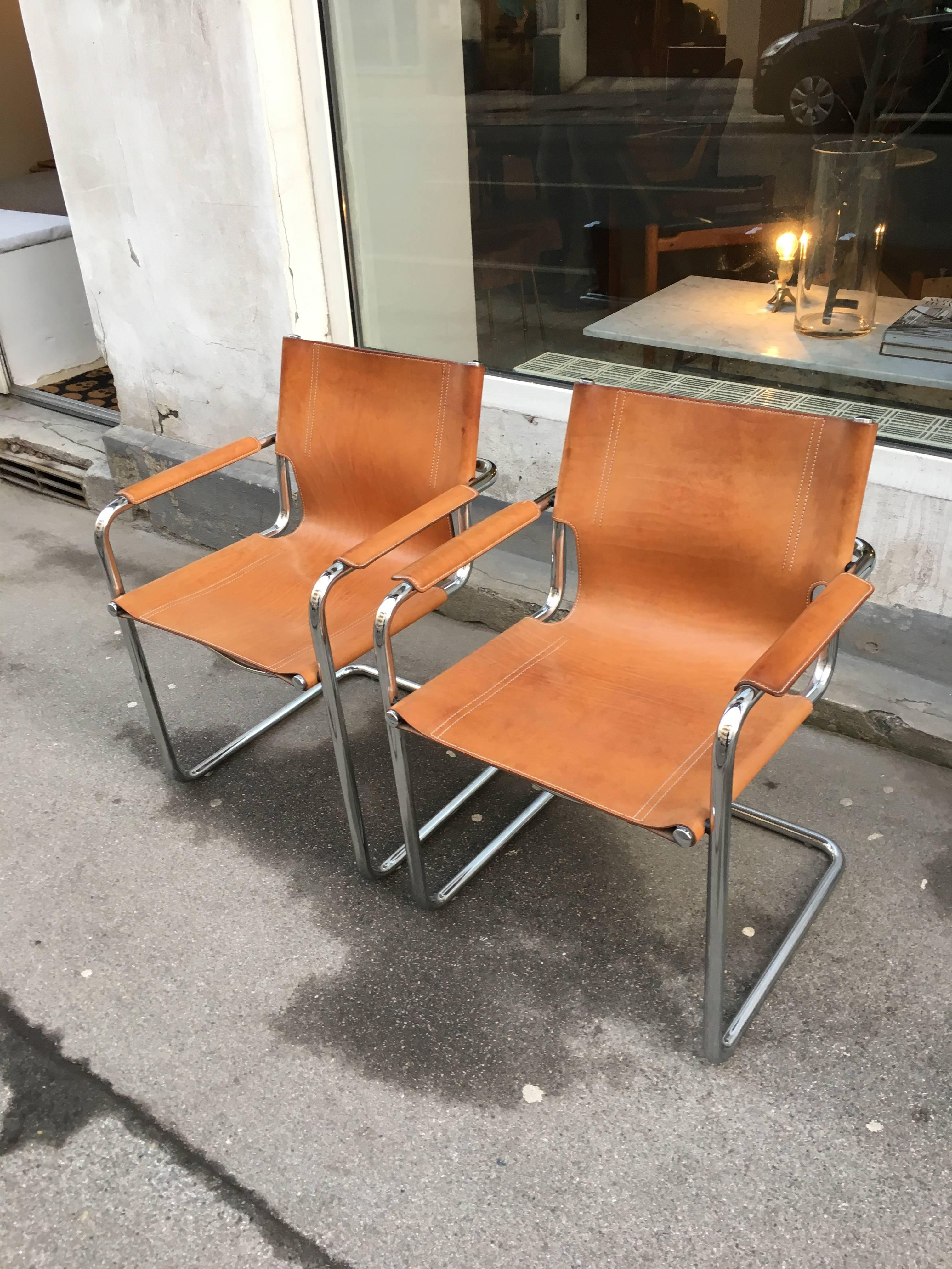 Fine pair of Italian leather Matteo Grassi visitor chairs. Desirably patinated in a gorgeous cognac colored Italian leather. Embossed marked on the back of each chair Matteo Grassi. The chairs are perfect vintage condition with just the right amount