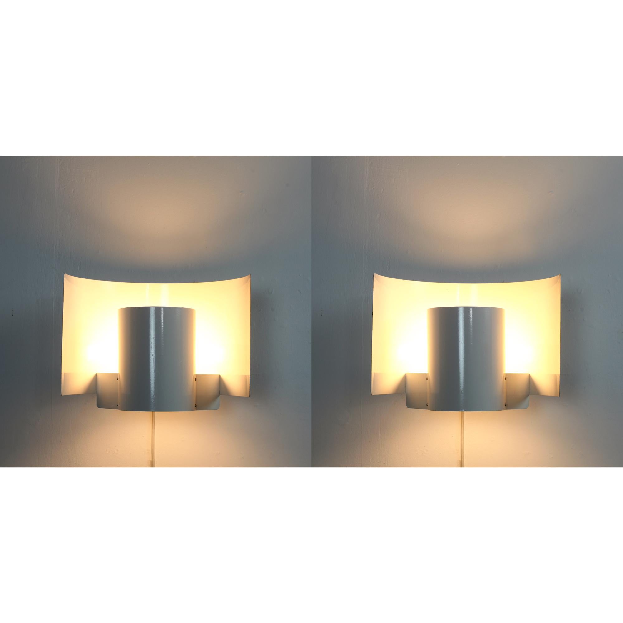Exceptionnel ensemble de 2 grandes appliques en métal laqué blanc de Bruno Herbst avec étiquette d'origine.
Suède années 1960. 
Un exemple remarquable de design scandinave du milieu du siècle, épuré et simple, dans sa conception.  et