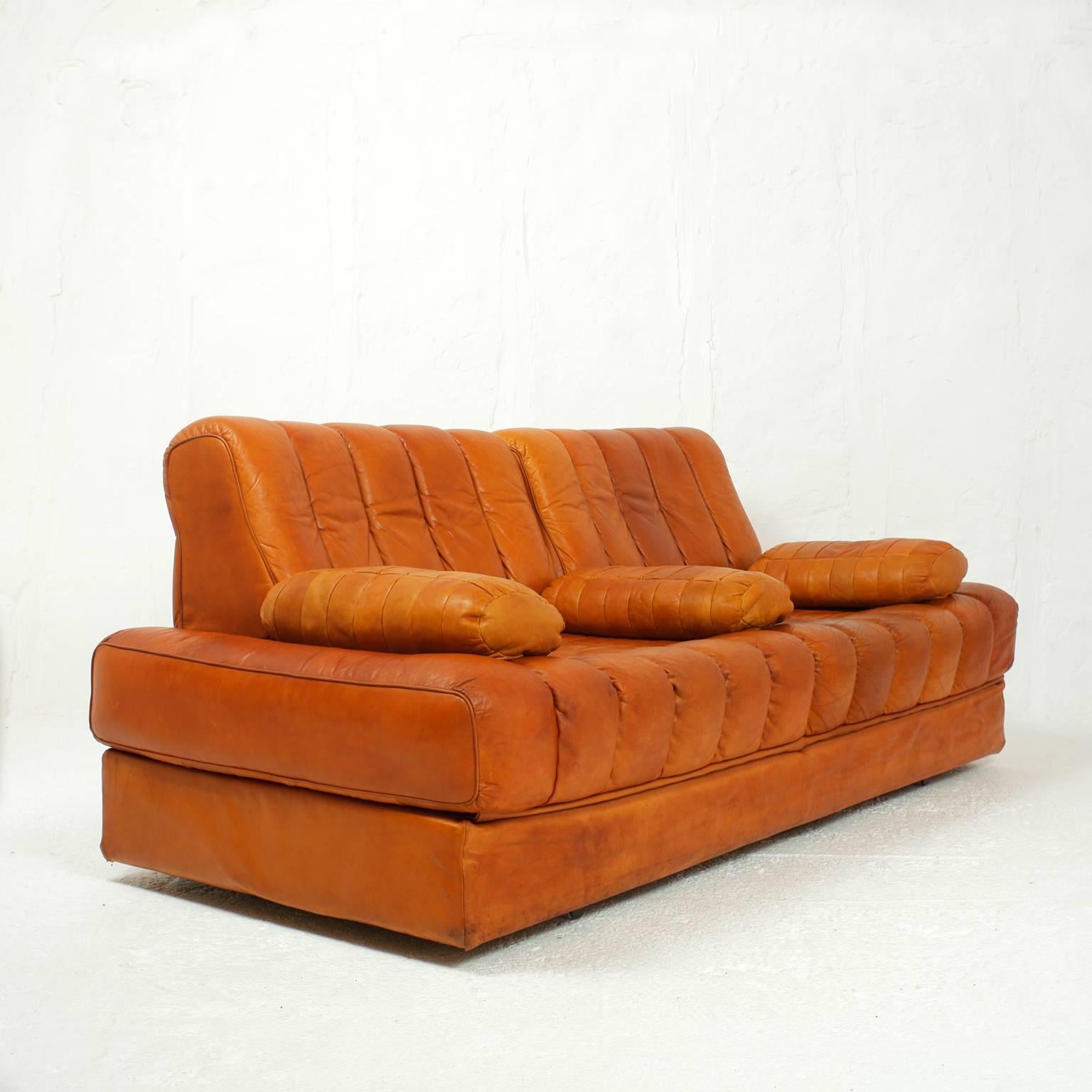 Cognac leather sofa from De Sede made in Switzerland, the DS 85 is convertible into a double bed.
Leather with nice patina, no more manufactured.
Three patchwork cushions.