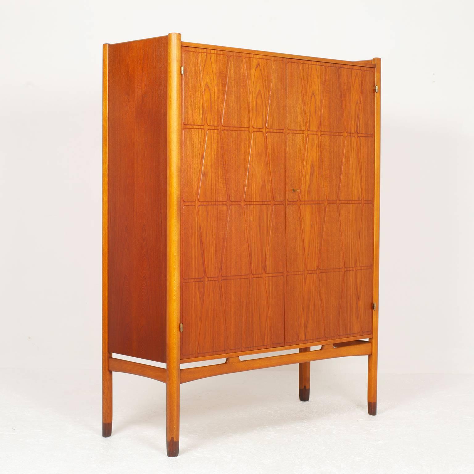 Cabinet by Yngve Ekström for Westbergs Mobler Sweden with beautiful carved doors. Six shelves and three drawers. Teak and solid beech legs.