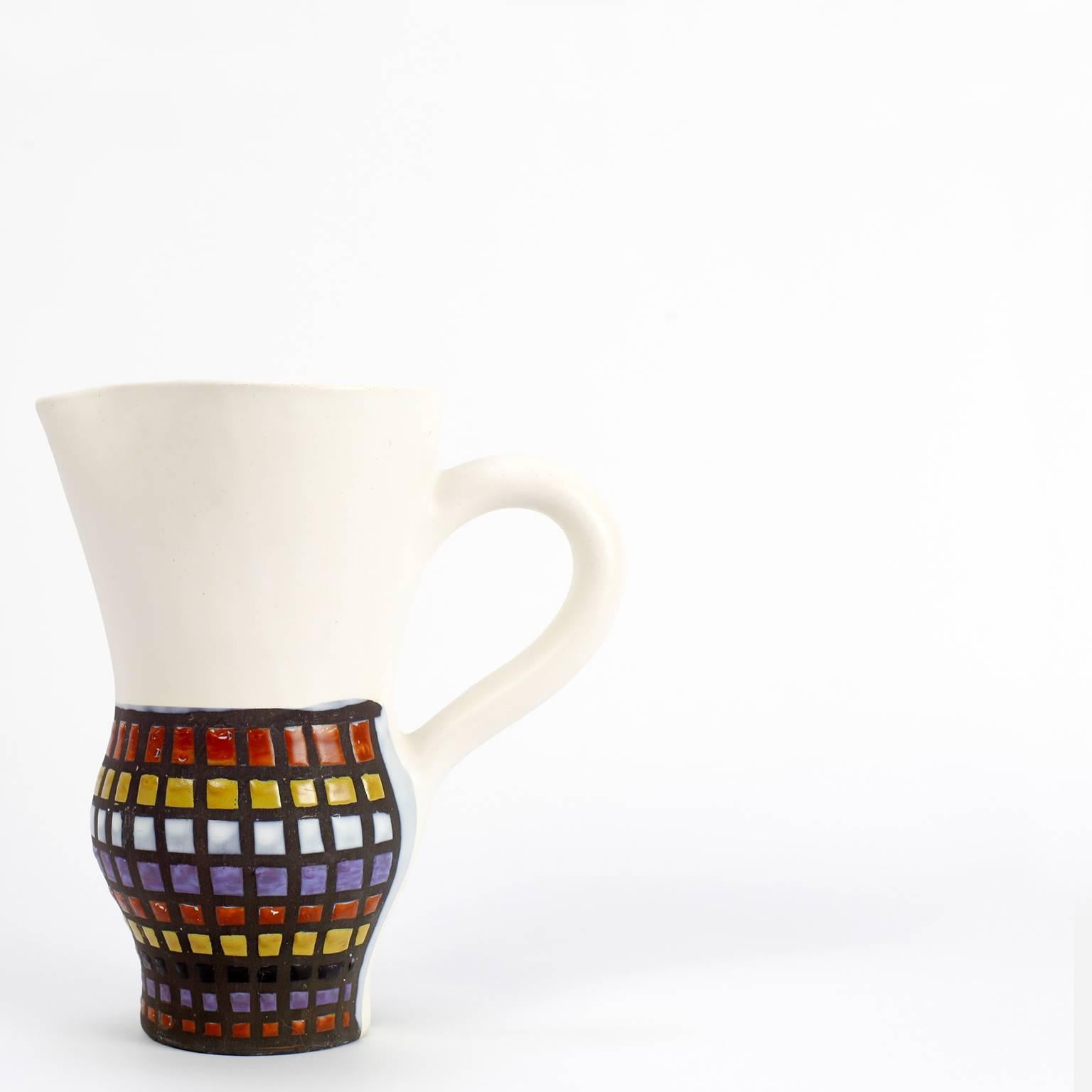Pitcher and four cups by Roger Capron: One ceramic pitcher and four cups (a chip on one cup) matte white and multicolored decor. Pitcher stamped under the base. 
Pitcher measures H 25 cm, cups H 11.5 cm.
