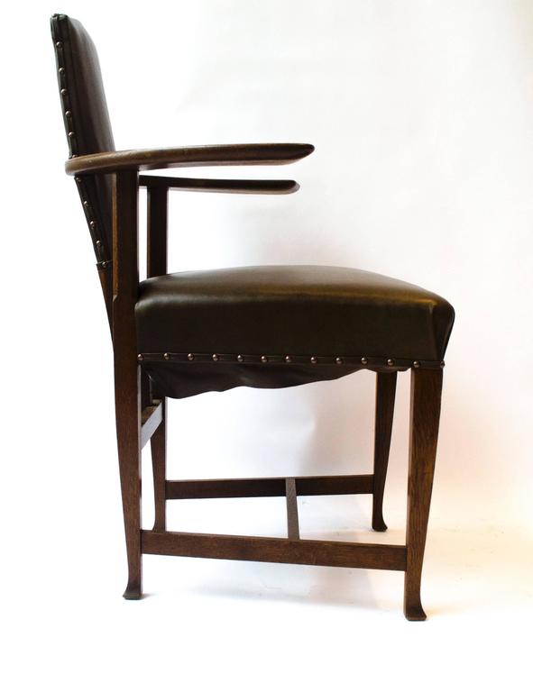  George Walton. A rare Arts & Crafts Glasgow School oak 'Abingdon' armchair. 
This design is quite radical, with large flat arms which protrude out incorporating the back legs and upright supports quite far back giving the chair a light and airy