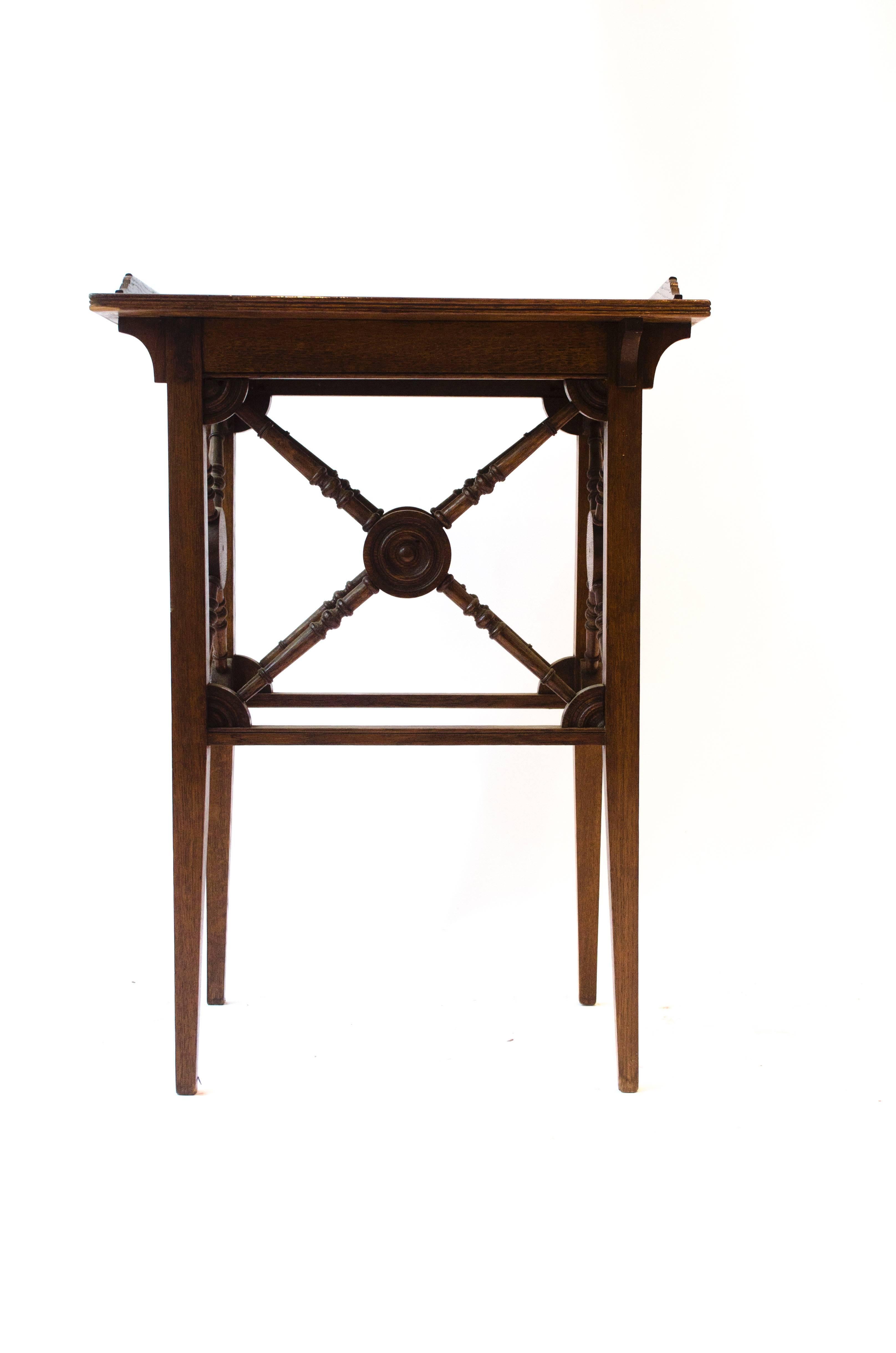 Jas Shoolbred. 
An Aesthetic Movement oak side table with a raised gallery to the top and a circular disc and turned cross stretcher details to each side with quartered circles to each corner.
Stamped Jas Shoolbred & Co.