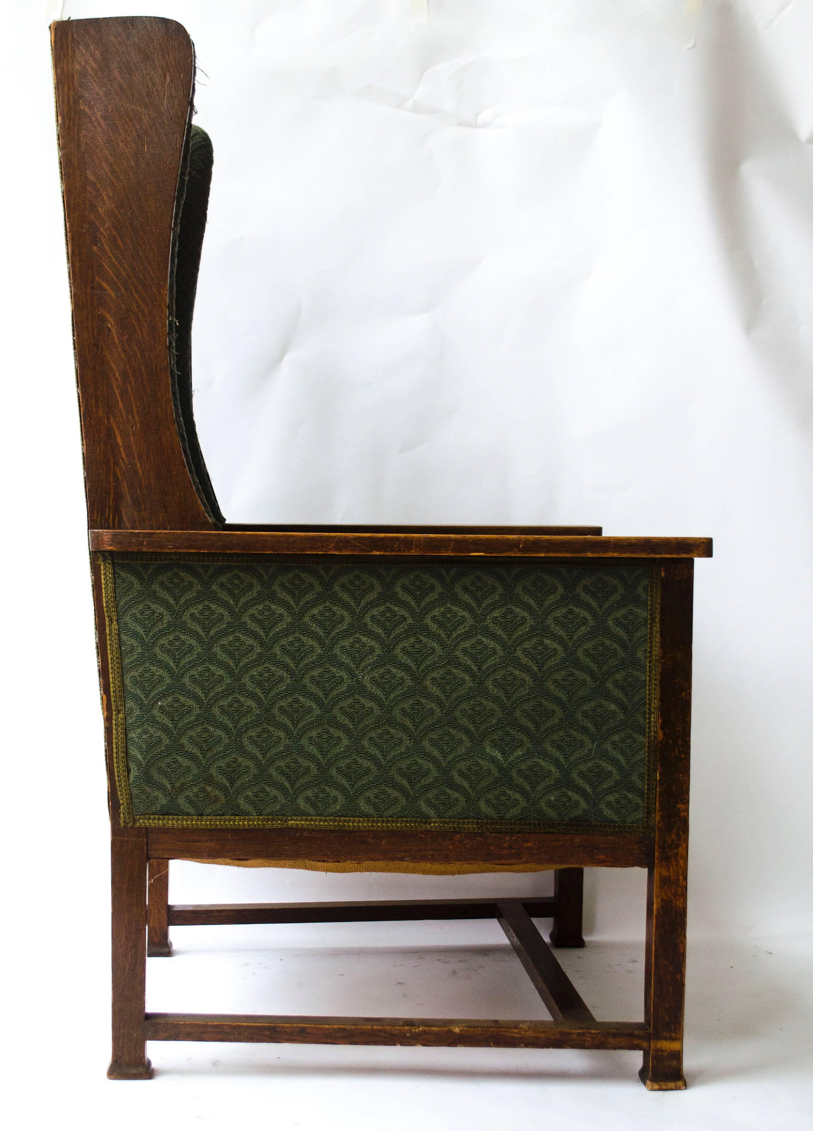 Mackay Hugh Baillie Scott (1865-1945), An oak high back wing lounge chair, the arm supports with chequer inlay panels, on square shaped feet. 
There are two armchairs identical to this one by M. H. Baillie Scott shown in 'Houses and Gardens', p. 298