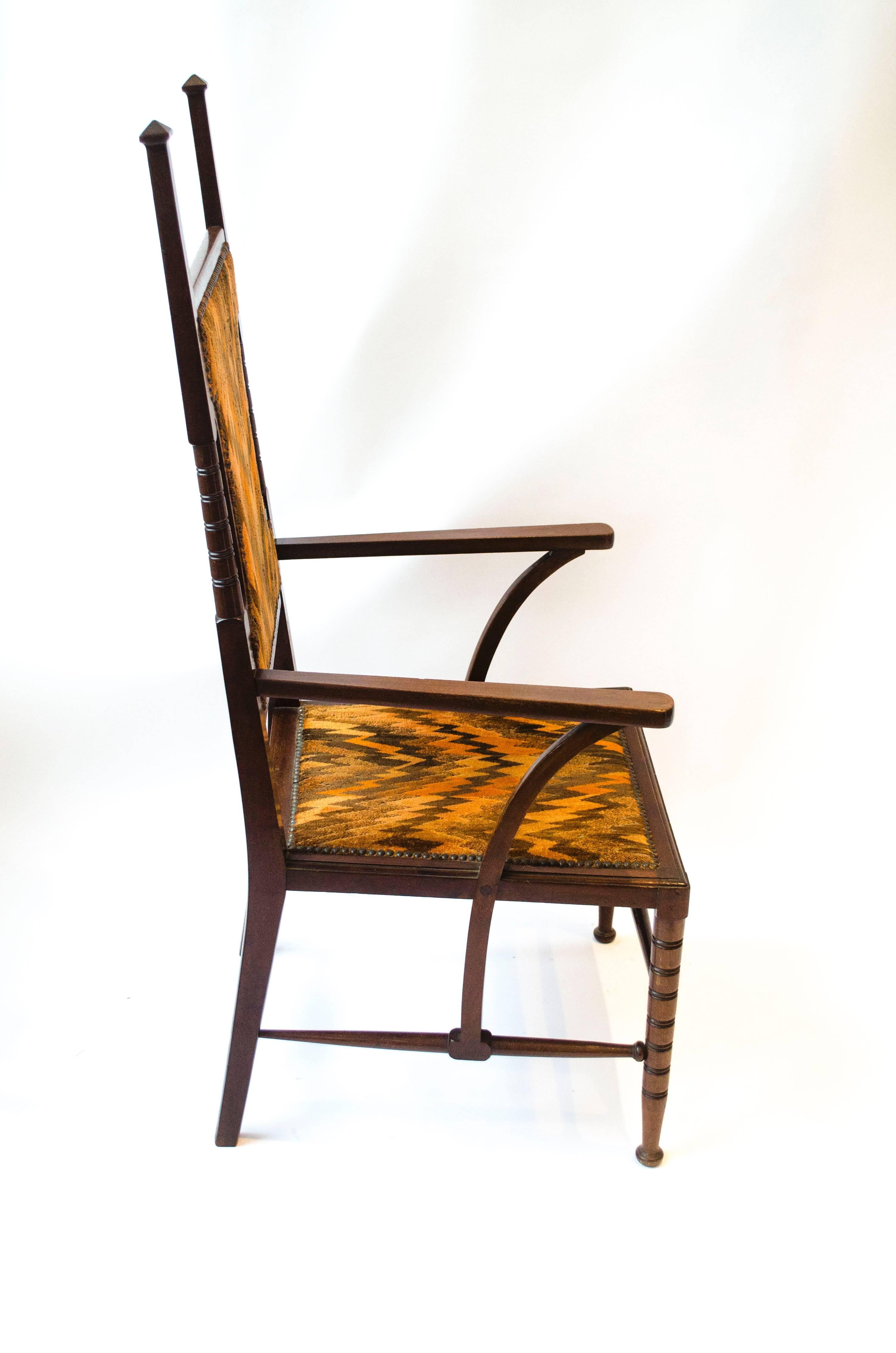 Liberty and Co. attributed. A good quality late Aesthetic Movement style Walnut high back armchair with square and turned supports, the arm supports continue down past the seat to meet the central square detail of the side stretchers, in turn, the