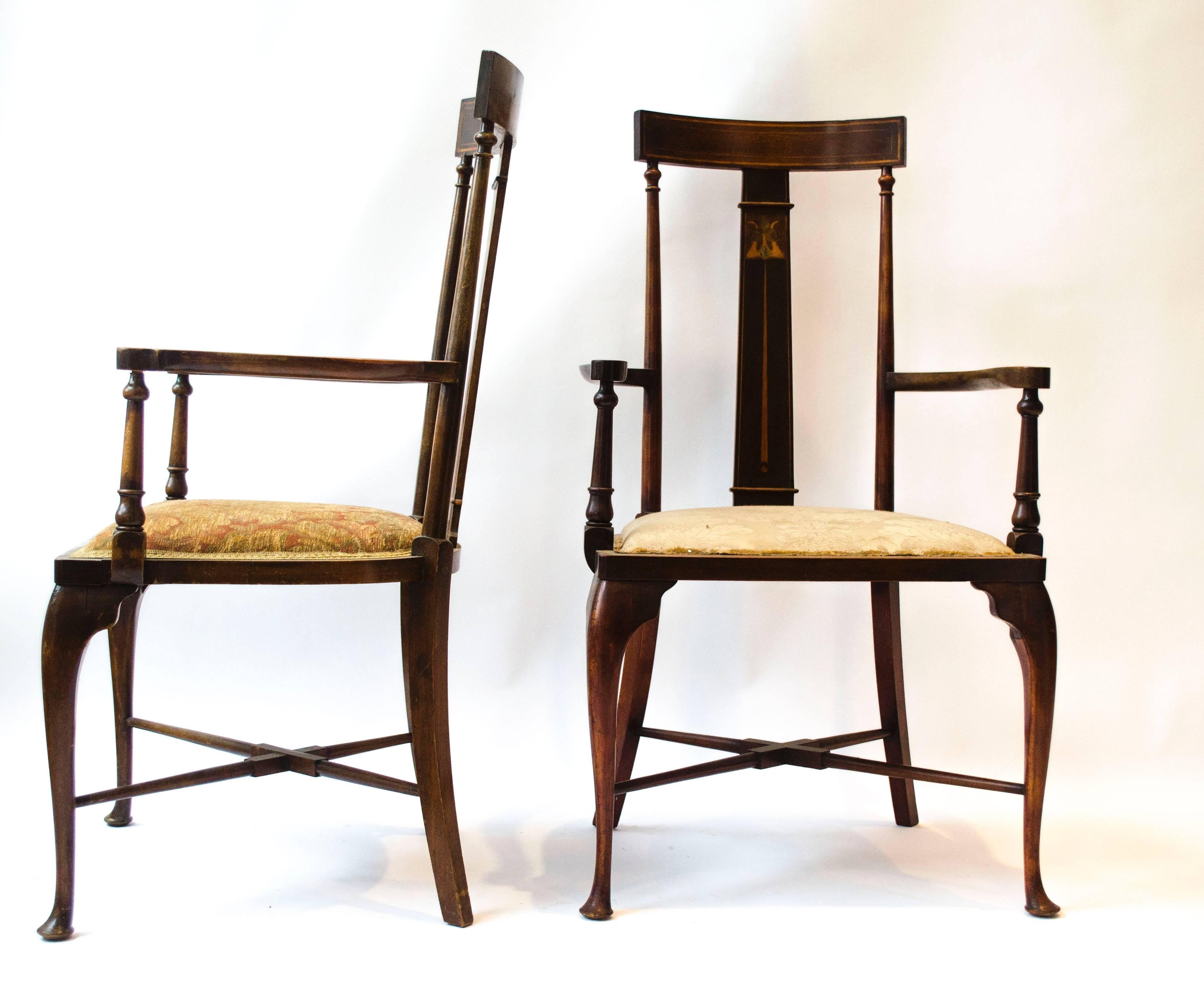 Style of Liberty and Co. Two identical Arts and Crafts mahogany armchairs with stylized floral details to the back inlaid with Abalone, Walnut, Boxwood and Stained Green Sycamore to the back, shaped arm rests and slender Queen Anne style legs united