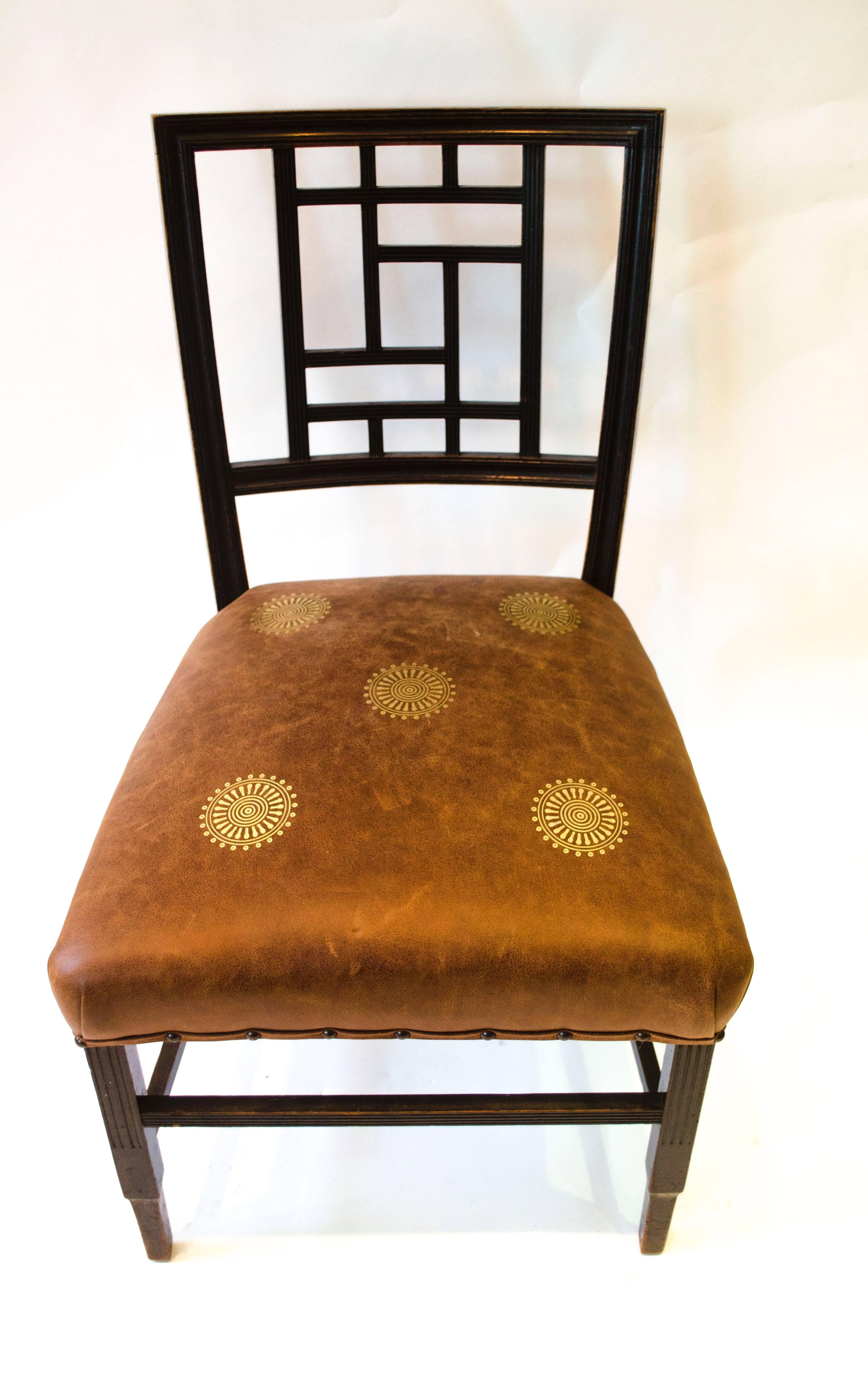 Edward William Godwin (attributed), an Anglo-Japanese ebonized side chair, circa 1875, probably by William Watt, with a lattice back, a later overstuffed gilt embossed leather seat, on square part-fluted supports. 
See Soros, Susan Weber 'The