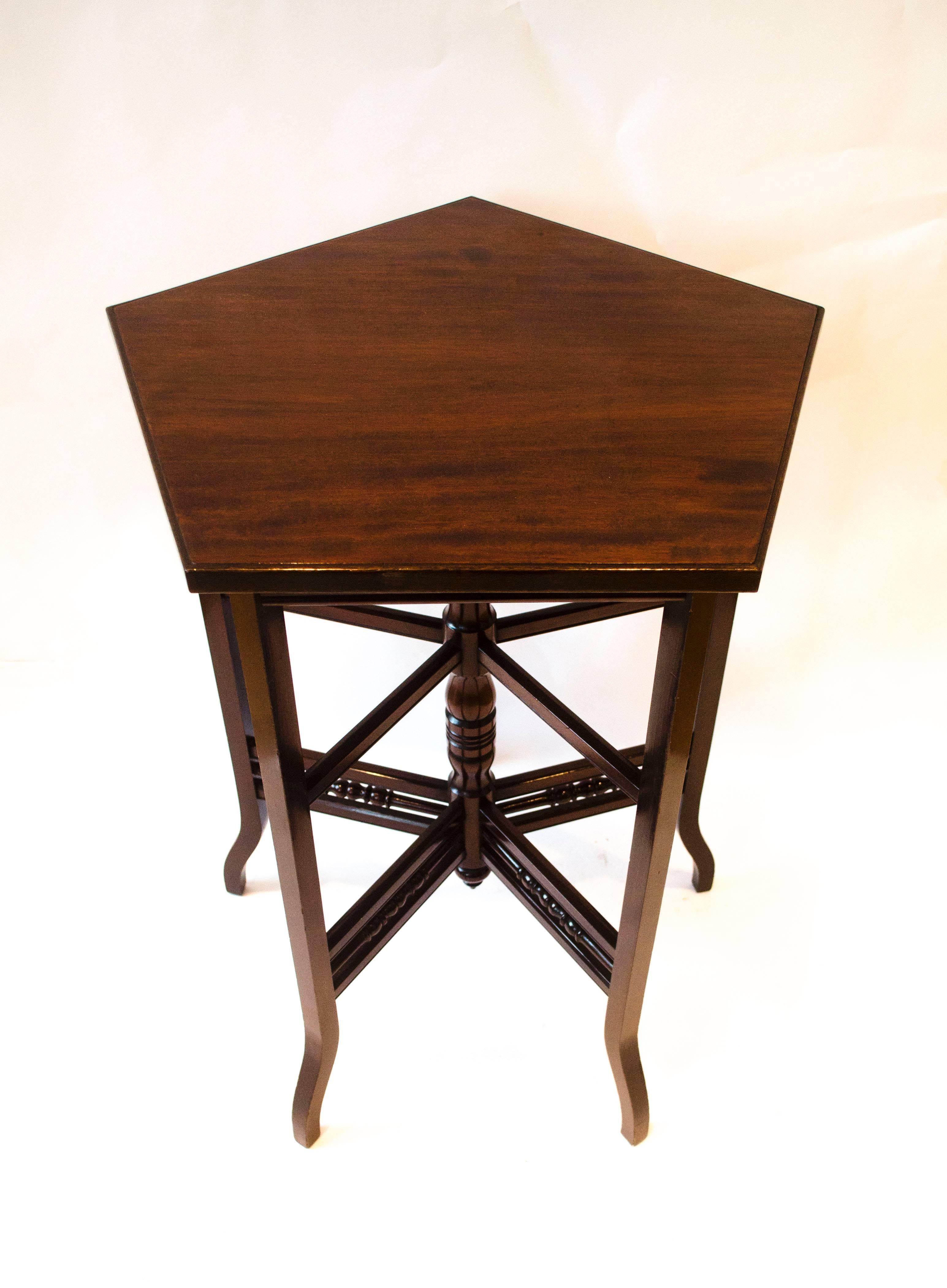 E W Godwin. Attr. An Anglo-Japanese five leg walnut side table with four sets of radiating stretchers using square bar and a row of turned stretchers uniting a central turned up right post.
Godwin used this design in a number of centre and side