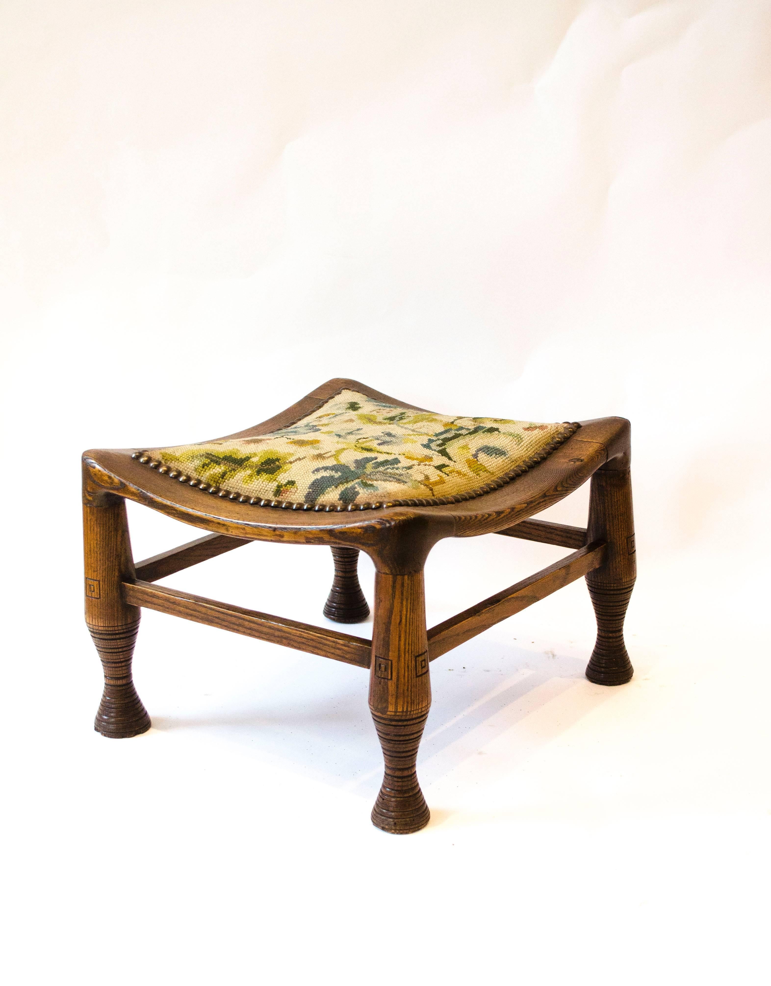 A rare early arts and crafts oak Liberty and Co Thebes stool.
  