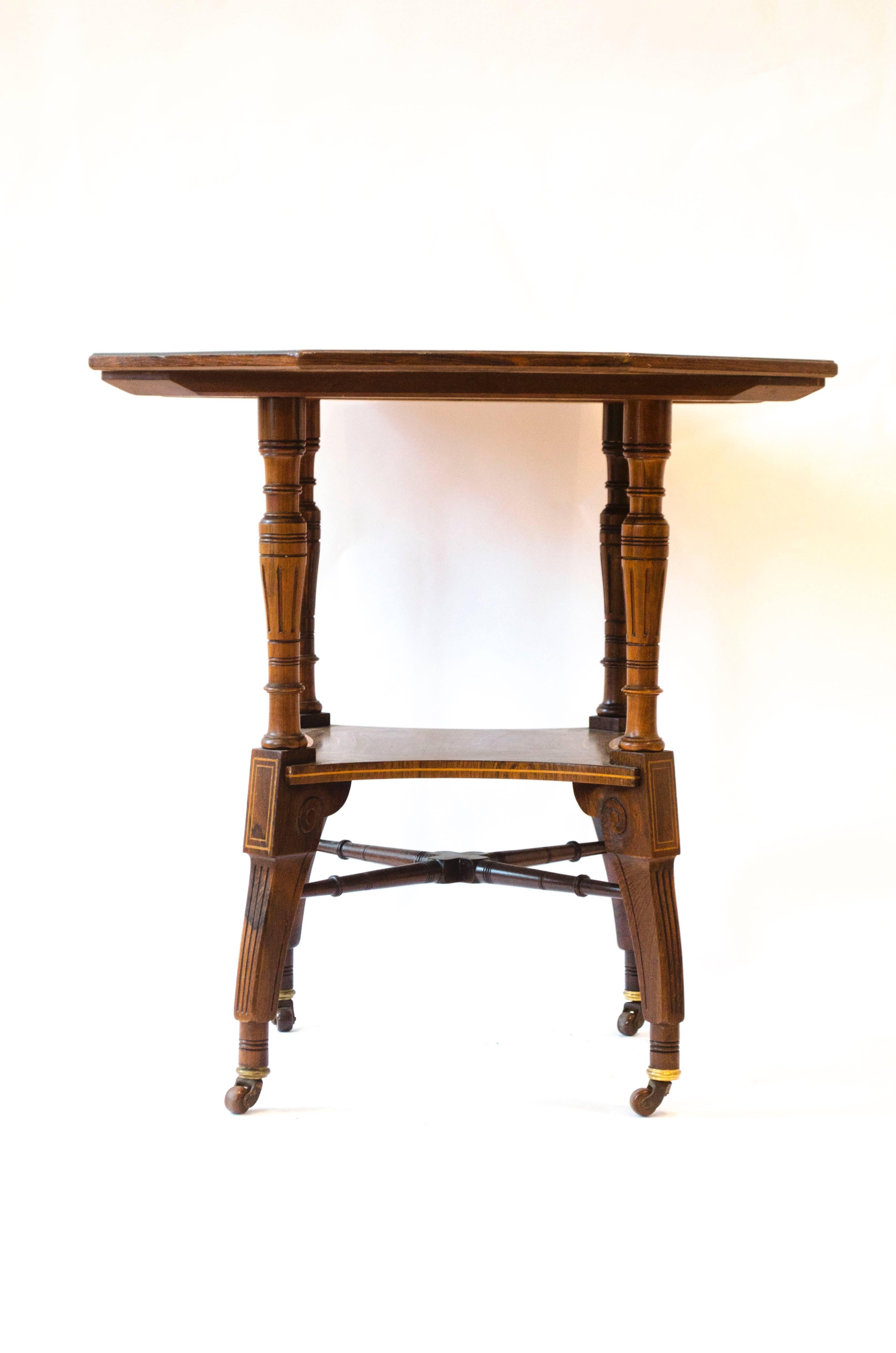 Jas Shoolbred.
An Aesthetic Movement octagonal rosewood side table with fruitwood stylized inlays to the top and string inlay to the top shelf and legs, carved circular details to the legs, united by lower cross stretchers.
