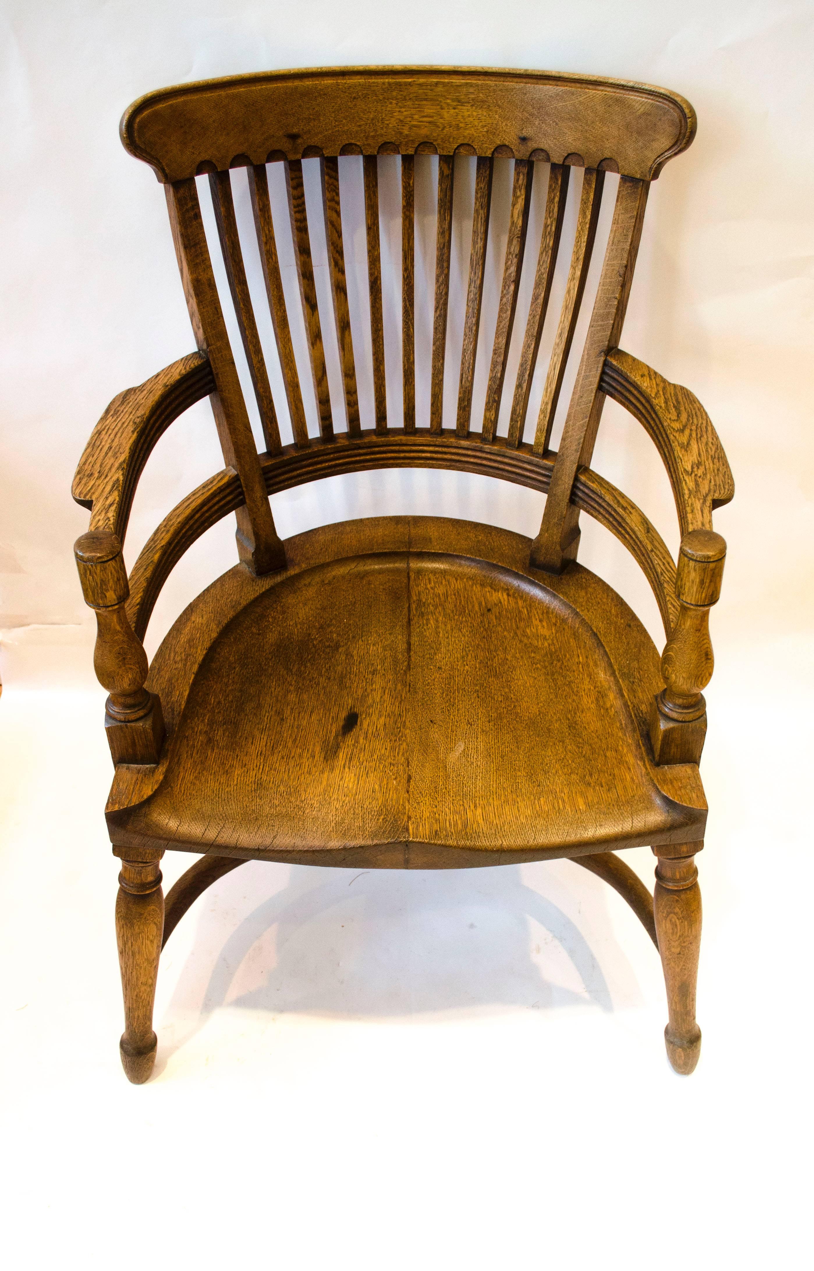 E. W. Godwin. Attr, An oak armchair with ergonomically perfectly shaped back, an incredibly comfortable armchair with a crinoline hoop stretcher.
Made by James Peddle or Smee. 
See the secular furniture of E. W. Godwin by Susan Weber Soros page 131.