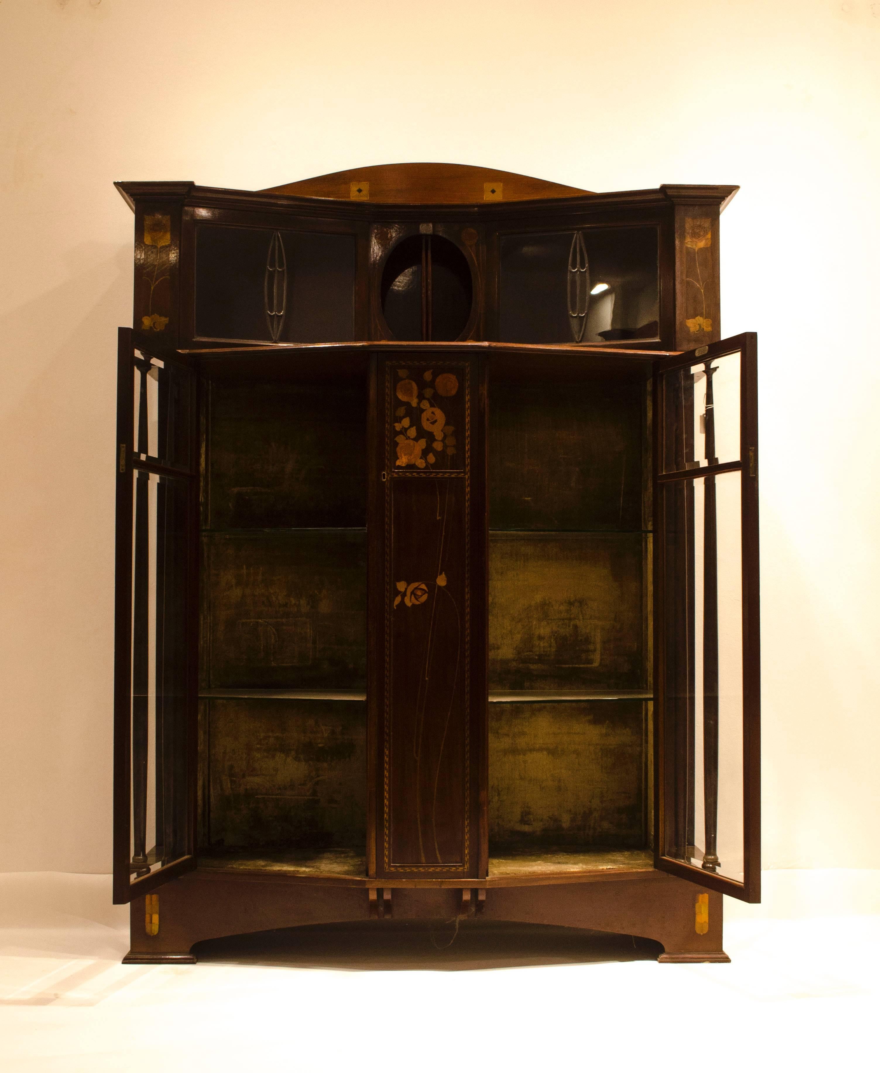 E. Goodall of Manchester, a fruit wood, inlaid, and leaded glass display cabinet with an array of Glasgow Rose and floral fruitwood inlays.
E. Goodall of Manchester were high-class manufacturers of the period who also made furniture for Arthur