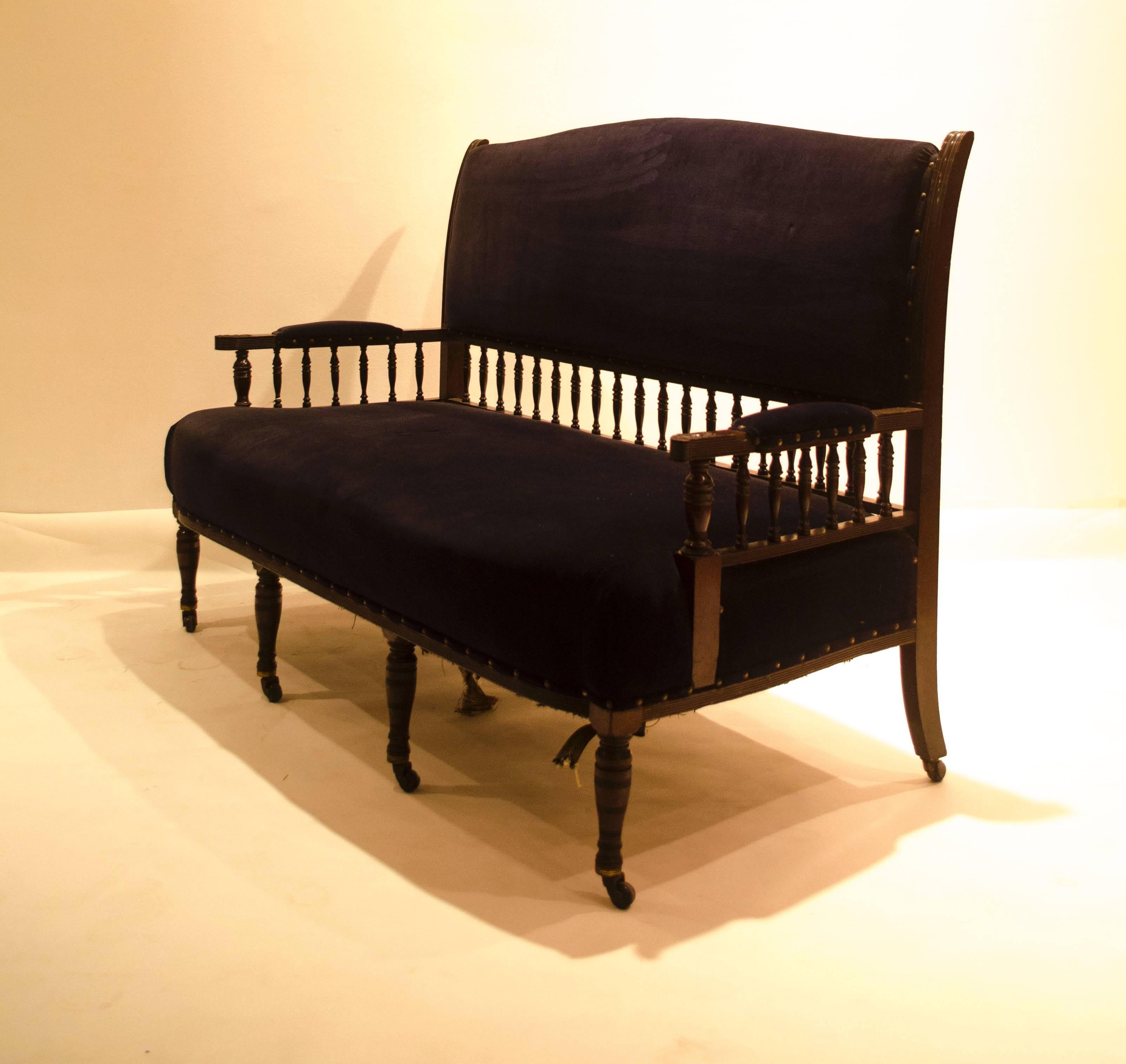 Collinson and lock, possibly designed by E. W. Godwin.
A fine Anglo-Japanese mahogany settee,  with subtle Japonesque detailing to the back uprights, each arm turns out in the Japanese style, with finely carved foliate details to the upper fronts
