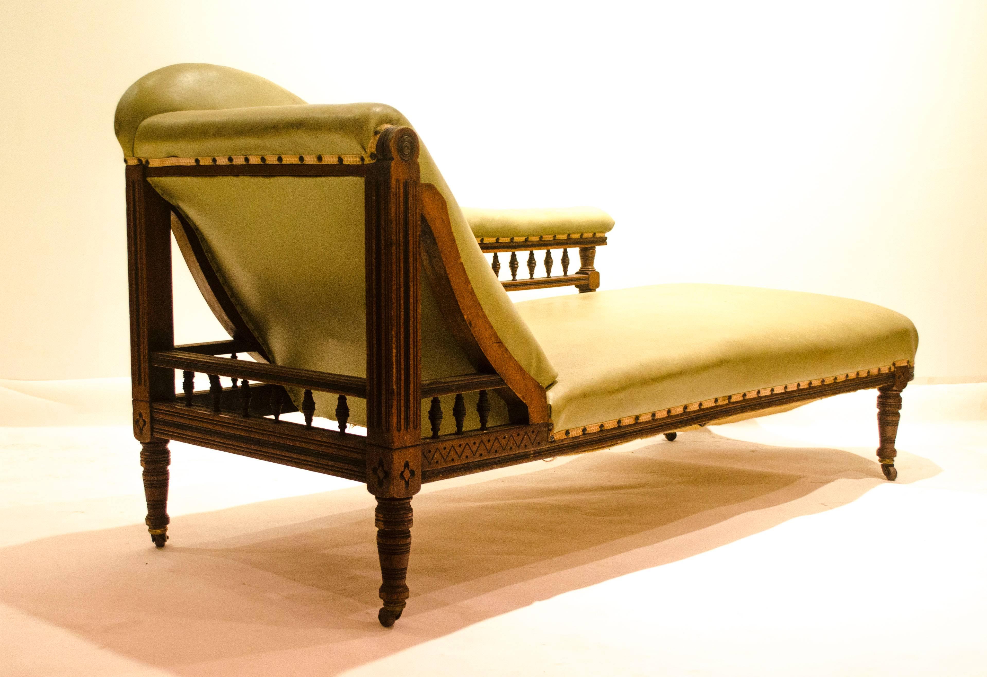 Thomas Collcutt (attributed) for Collinson and Lock.
An Aesthetic Movement Walnut and ebonised chaise longue, with triangular 'A' frame to one end, ebonised tramlines throughout, with a lower turned gallery and turned feet, the semi upholstered back