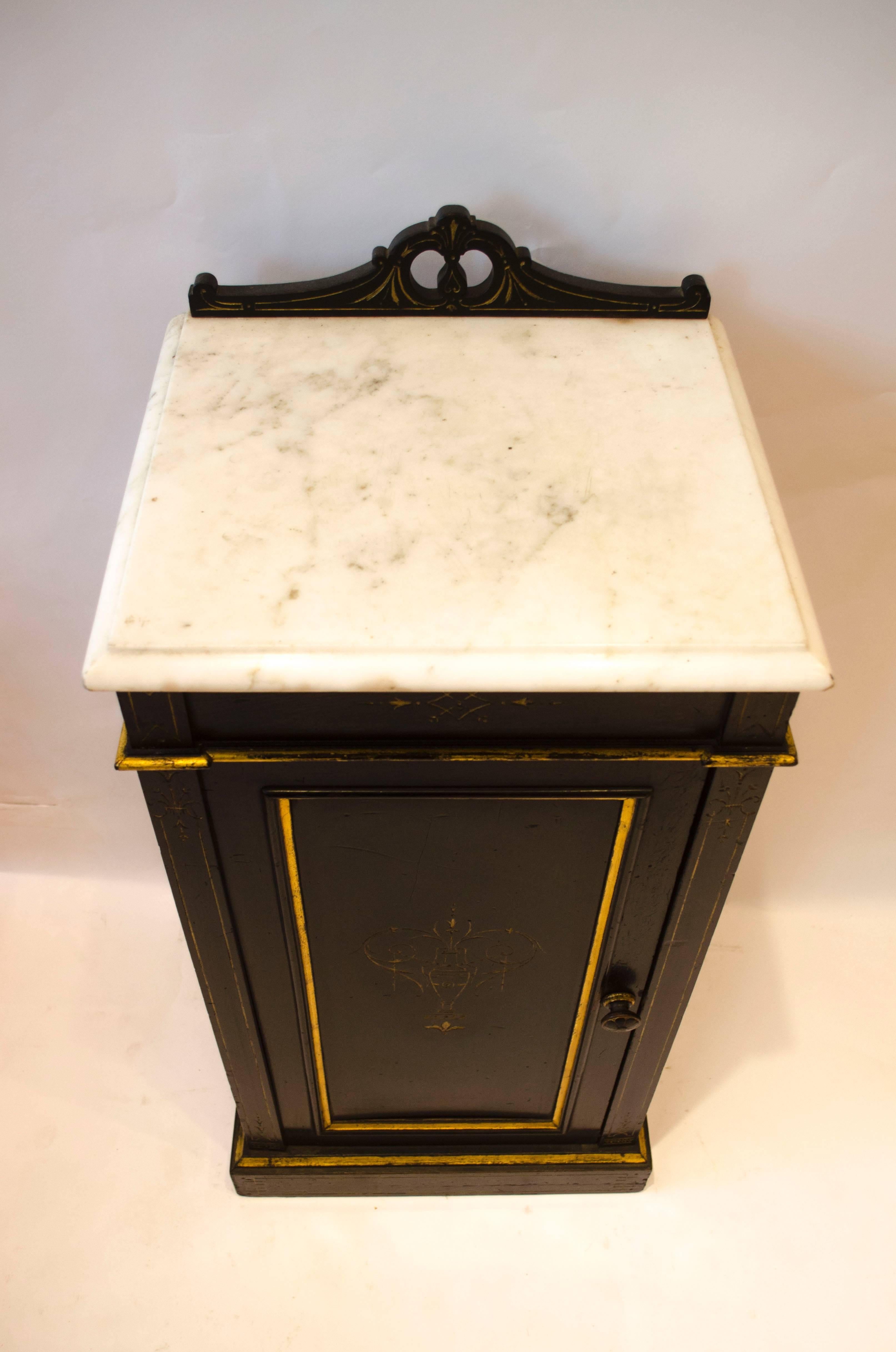 Rare table de chevet ébonisée et dorée de Heal and Son Aesthetic Movement, avec dessus en marbre et décor doré incisé. Le cachet de Heal's et Son London est apposé sur le haut de la porte.
Heal's a commencé à fabriquer des meubles en 1801.
 