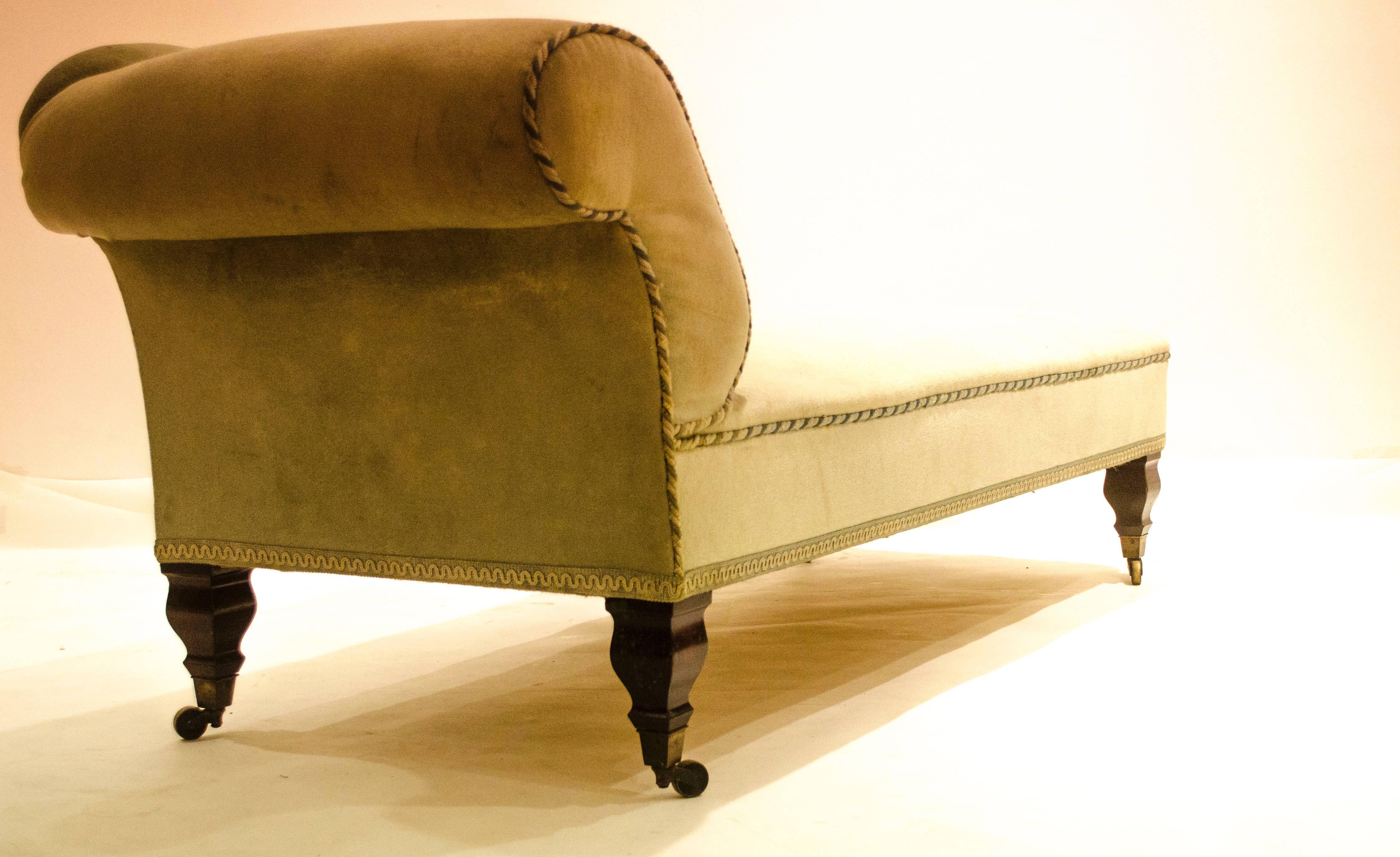 George Washington Jack for Morris and Co., a mahogany 'Saville' chaise longue, re-upholstered in green velour, on mahogany legs with brass casters.