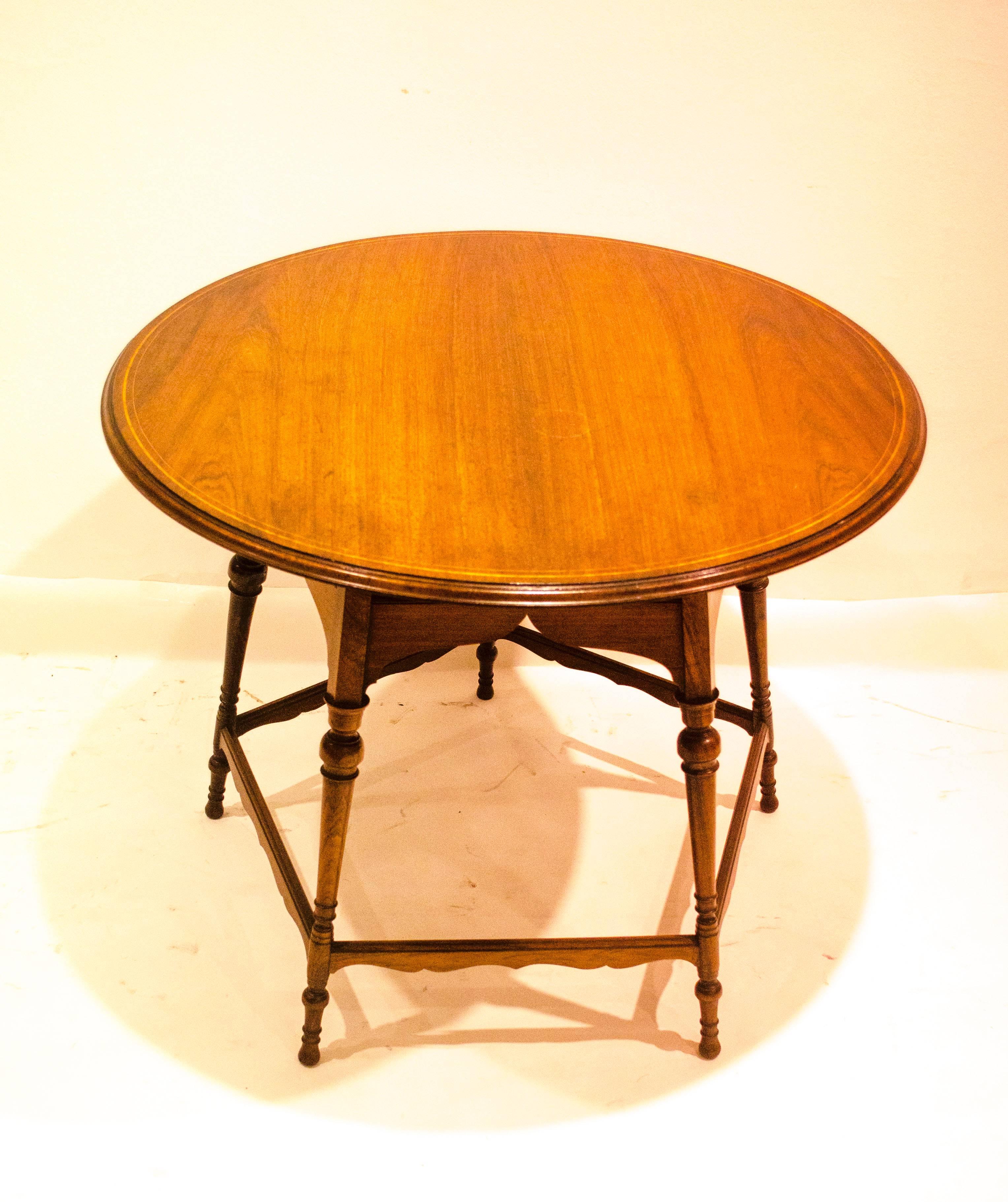 Collinson & Lock. In the style of E W Godwin. 
Two Aesthetic Movement Rosewood and line inlaid circular tables, with Japanese style shaped undertiers below, on five turned and tapered legs each table with subtle differences to the turnings, joined