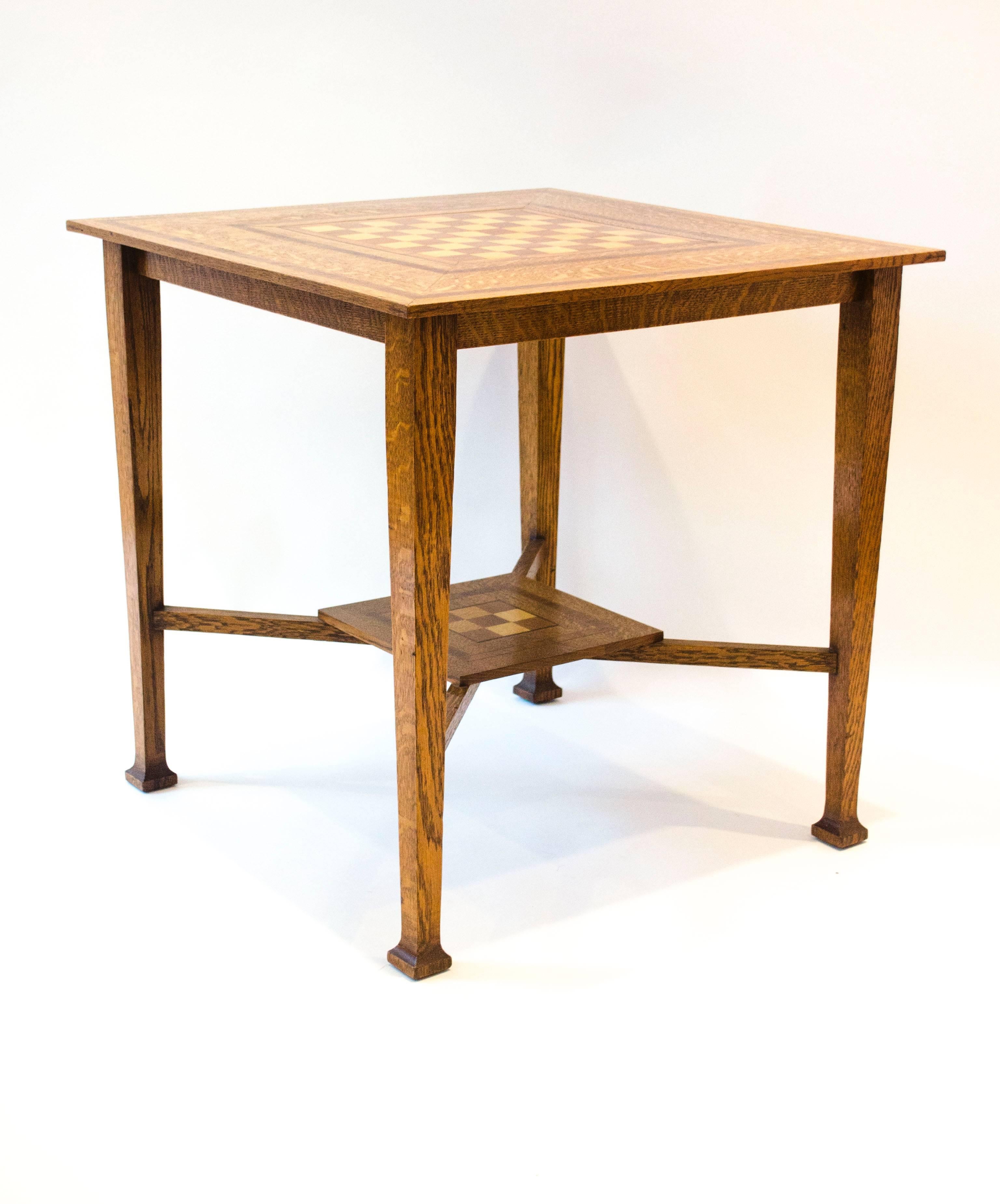 Liberty & Co attributed, A good Arts & Crafts 1/4 sawn oak chess table with alternating burr sycamore and walnut squares to the top surrounded with mahogany and ebony banding with further rosewood cross banding, edged with boxwood stringing, on
