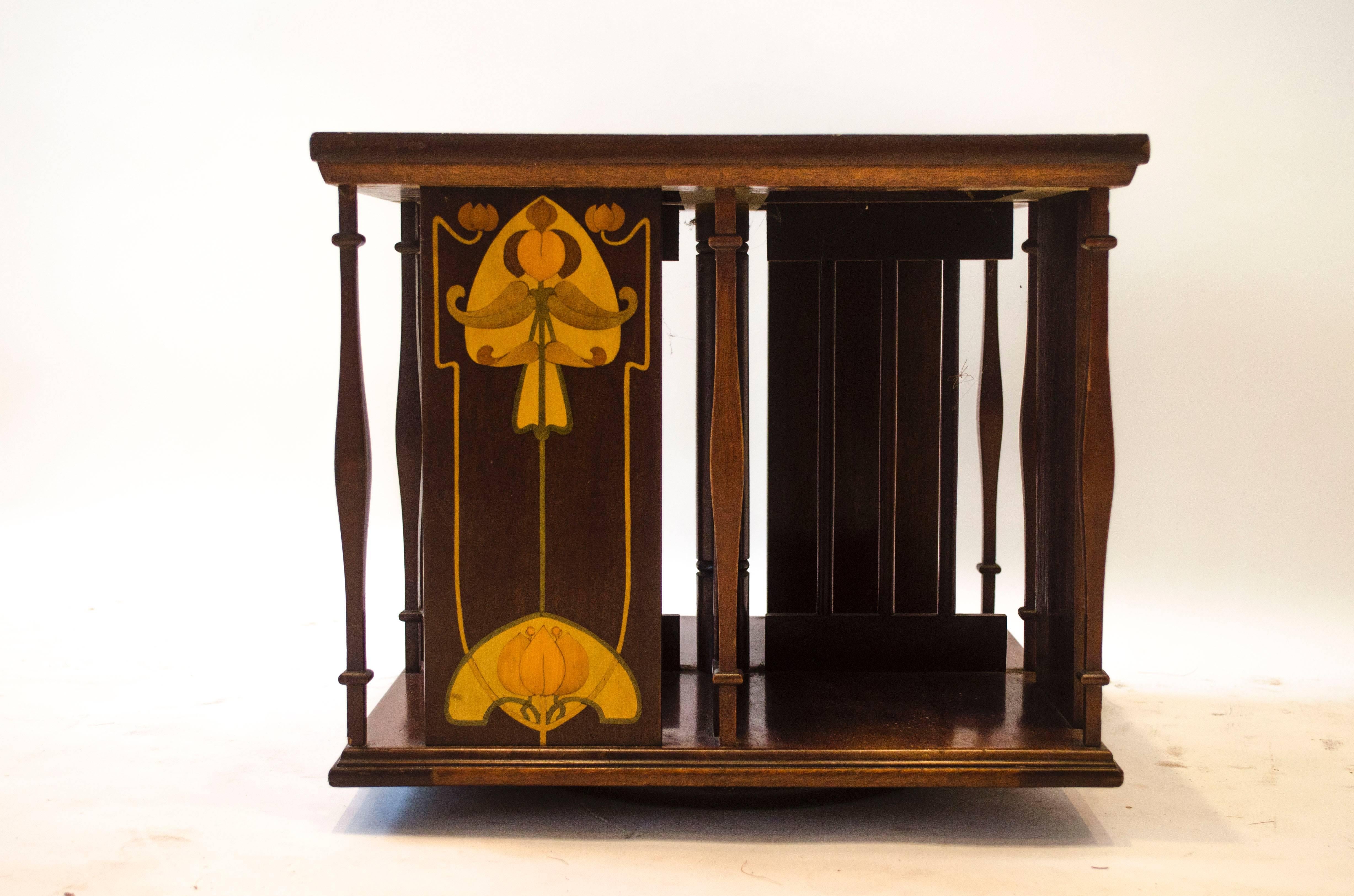 A good Arts and Crafts mahogany table top revolving bookcase by Shapland and  Petter with wonderful stylised floral inlays to the top and to the sides with S&P's unique shaped spindles and four compartments to hold books.
It will accept books upto a