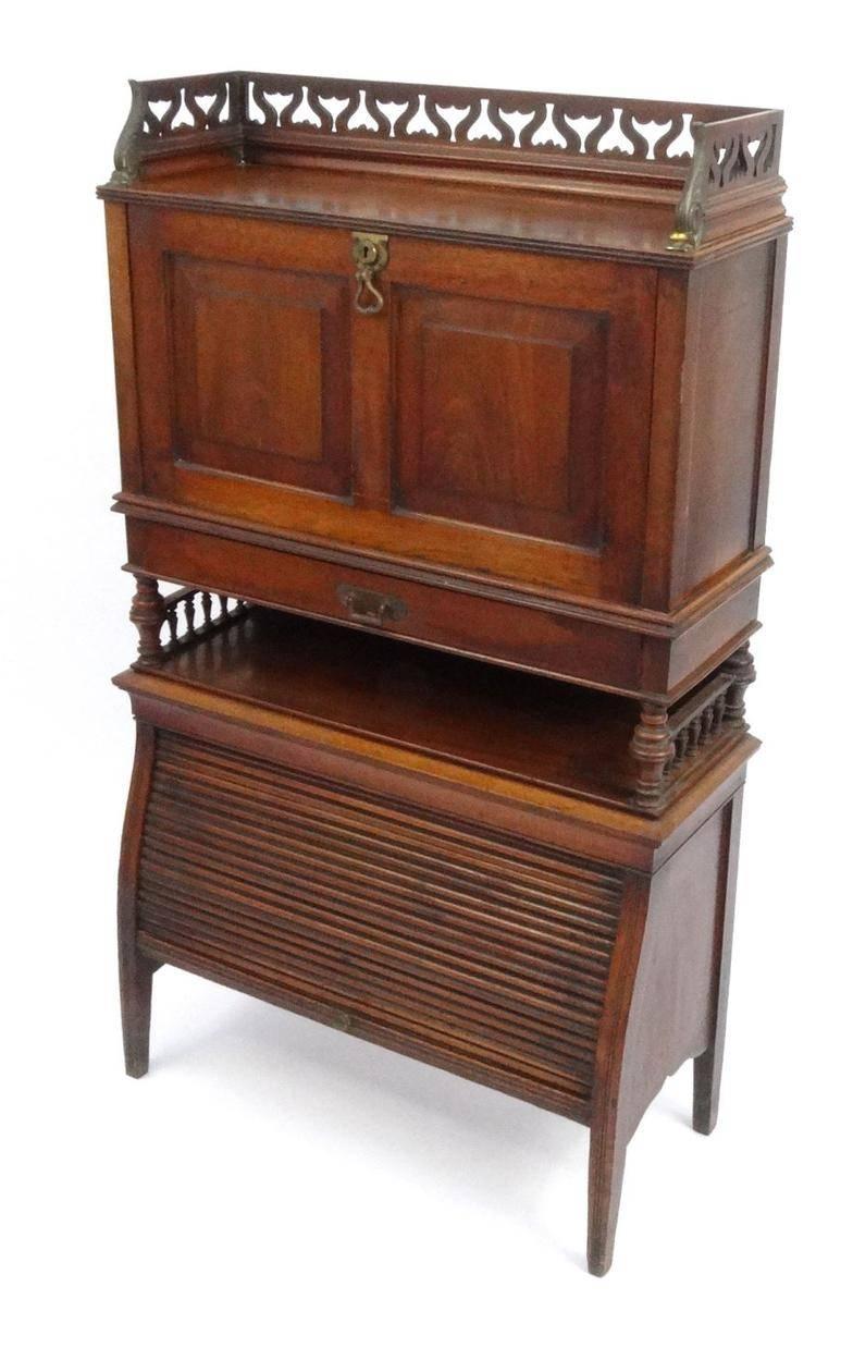 An aesthetic movement mahogany secretaire bookcase with gilt brass mounts and lower tambour front.