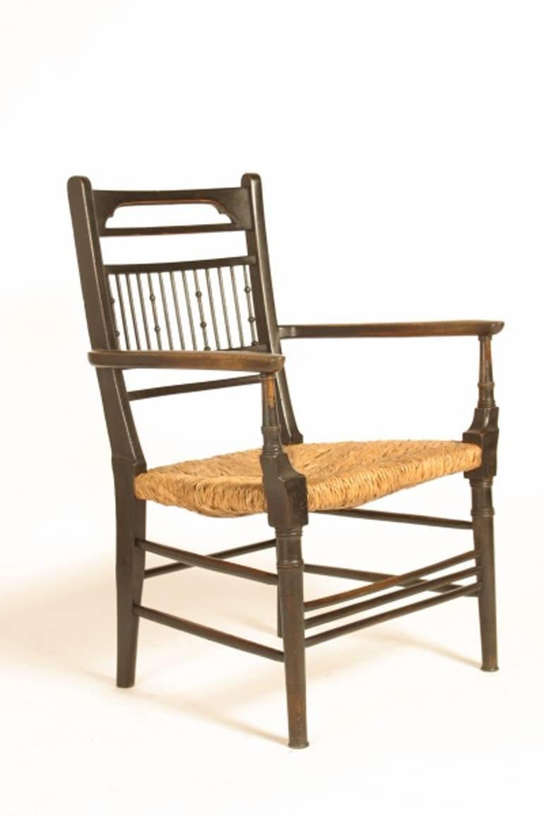 Edward William Godwin (attributed) for William A. and S. Smee, an Anglo- Japanese walnut spindle back armchair, with a re-rushed seat, Godwin designed for W.A. and S. Smee, 89 Finsbury Pavement, London and his designs were exhibited by them at the
