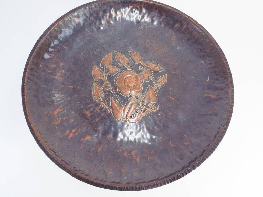 A rare handmade Birmingham Guild of handicraft copper center piece, with stylised repouse floral details to the surface, on triform base with curled under feet. Stamped BGH.