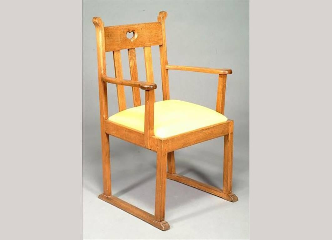 Una coppia di poltrone in quercia Arts and Crafts nello stile di Liberty & Co., con intagli a cuore e piedi a slitta.