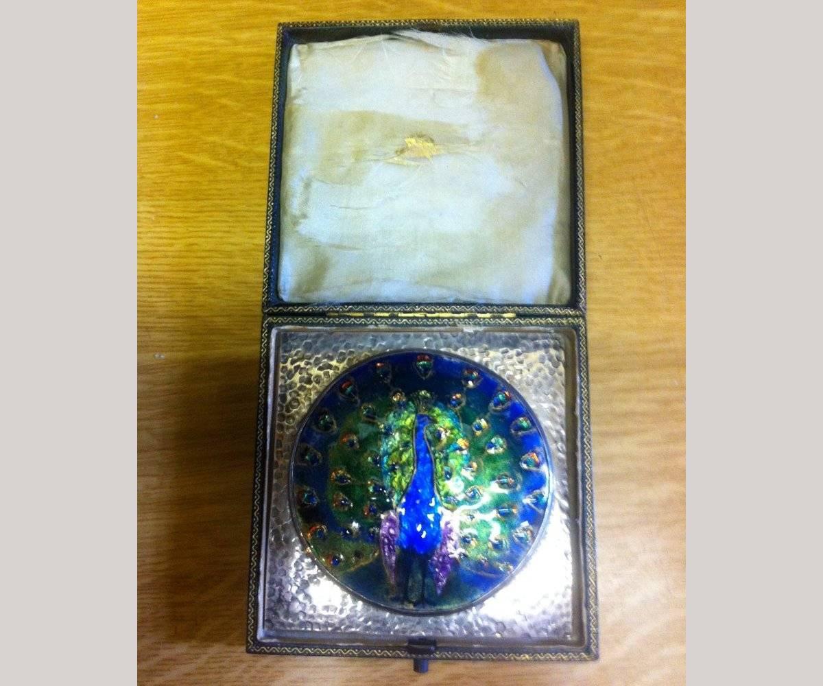 A beautiful Arts and Crafts peacock enamel mounted in hand beaten silver frame attributed to C R Ashbee and The Guild Of Handicraft, in its original case, the colors are the most vibrant I have ever come across and the enamel is in mint condition,
