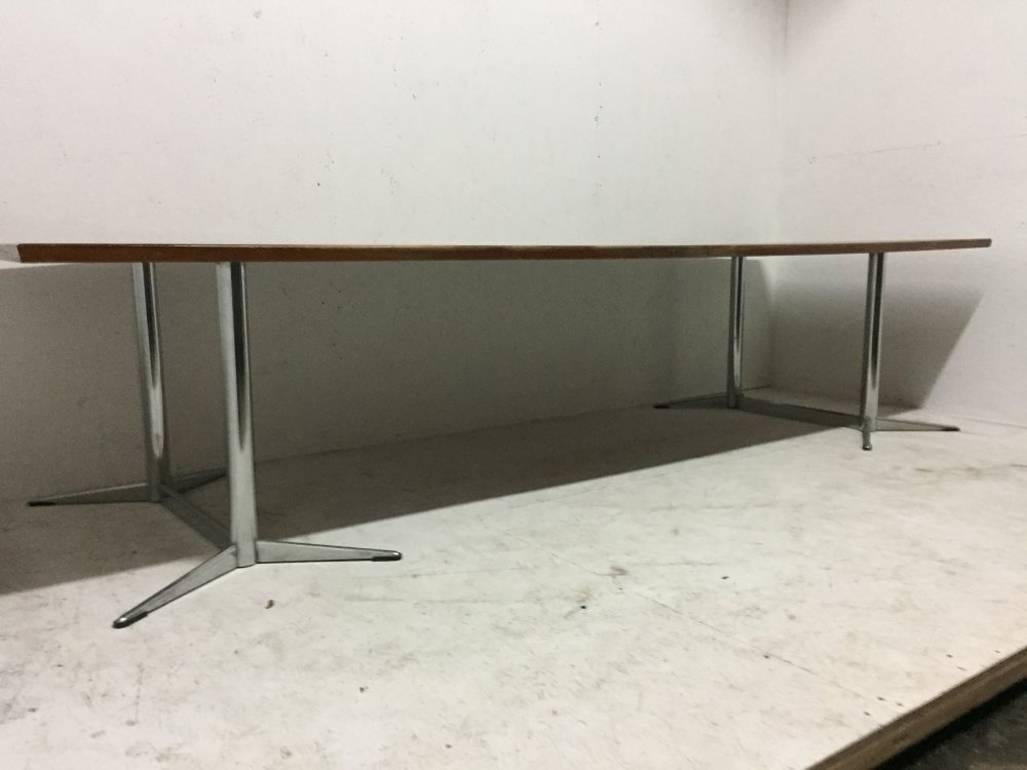 Heals. A super quality large Teak boardroom or dining table with a subtle curvaceous top on a pair of chrome twin pedestal legs with extending angular feet. Retaining the original Heals circular disc to the underside. A nice example that