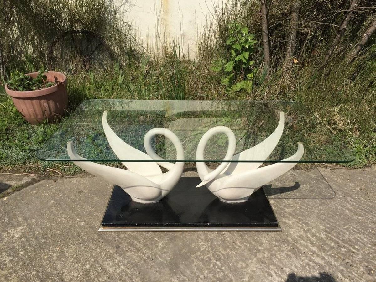 A rare coffee table by Maison Jansen with white composite swans with glass top, on a black gilt base. Signature to swans.