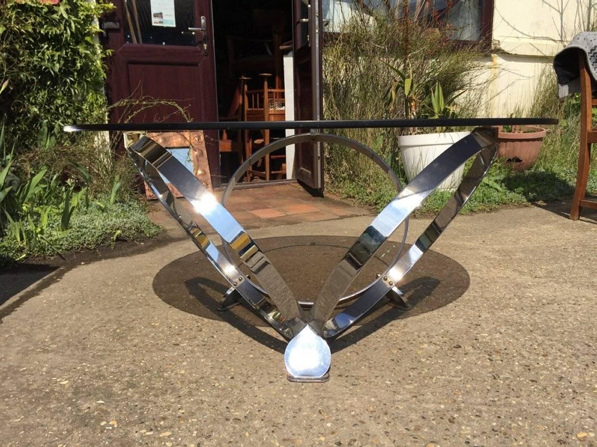 Knut Hesterberg in the style of.
A modernist 1970s chrome and smoked glass coffee table with three circles joined together uniting to make a clever triple elliptical design that all stands on little pad feet.