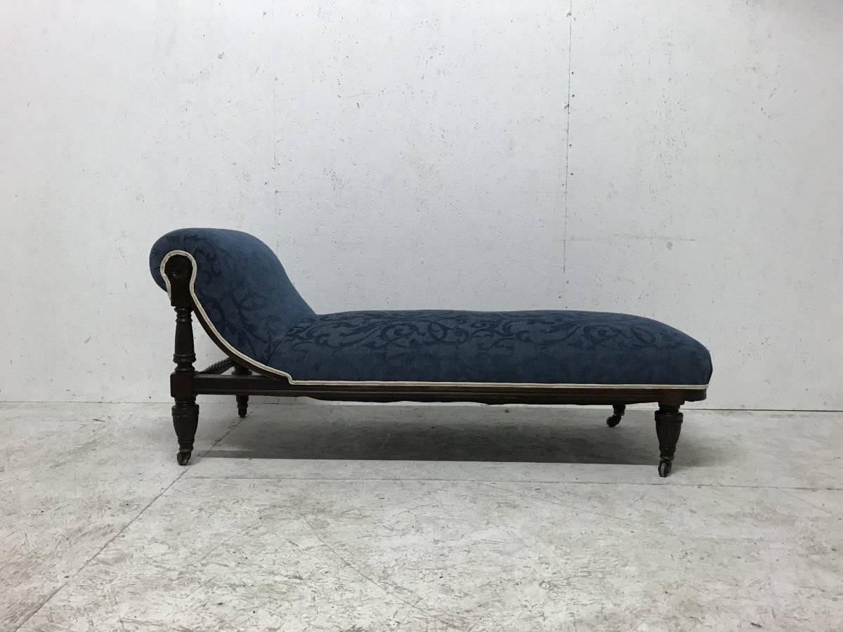 A good quality Aesthetic Movement Mahogany chaise longue attributed to Morris and Co. with stylised carved florets to the upper resting supports and spiral turned details to the upper back legs and to the cross stretcher, with bulbous fluted legs on