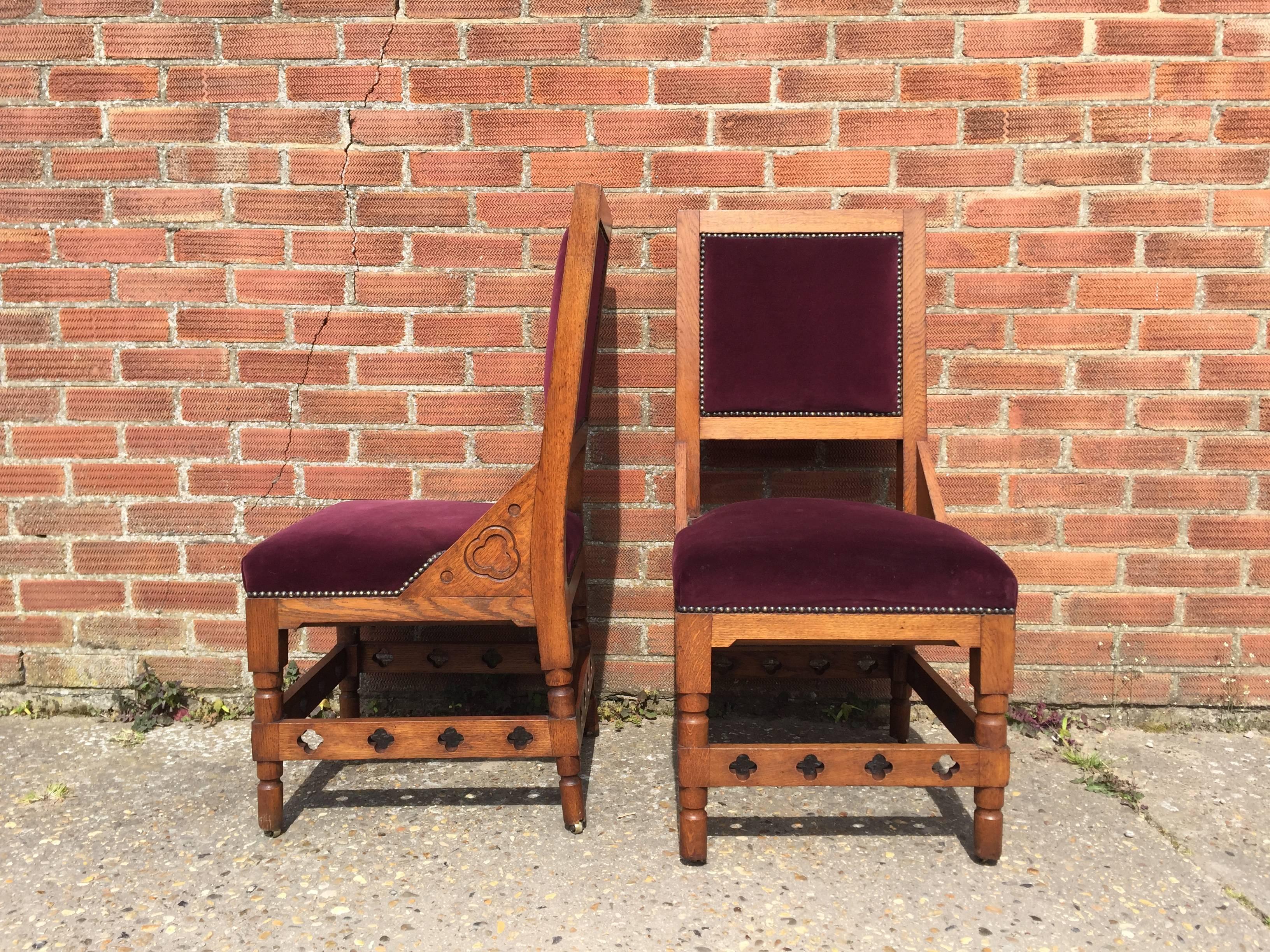 An interesting high quality set of four architectural gothic revival oak dining chairs with blind trefoil carving to the triangular side supports and through quatrefoil details to the stretchers with turned and square section legs with original