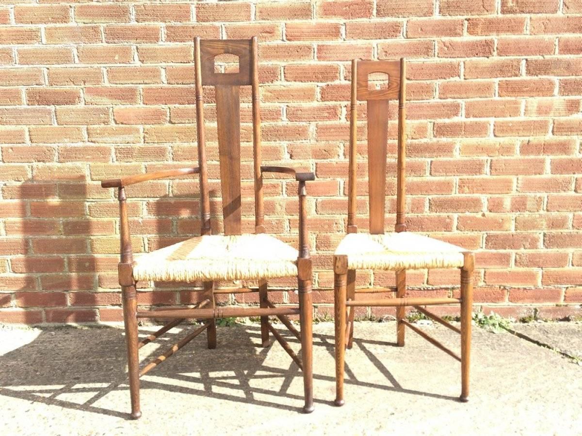 E G Punnet Attri, for William Birch Set of Four Glasgow School Oak & Rush Chairs and probably made by William Birch retailed by Liberty and Co, consisting of two armchairs two singles, with stylised cut-outs to the head and angular back rests with