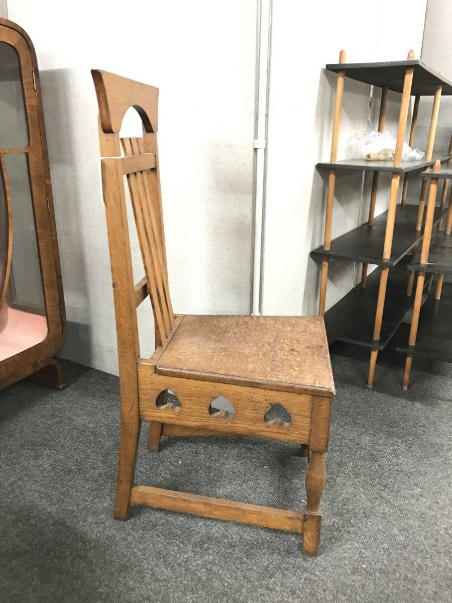 Shapland und Petter. Ein seltener Arts & Crafts-Stuhl aus Eiche im Stil von M. H. Baillie Scott mit schräg gestellter Rückenlehne und umgedrehten Herzausschnitten um die Schürze unterhalb des Sitzes auf geformten und blockierten Beinen.