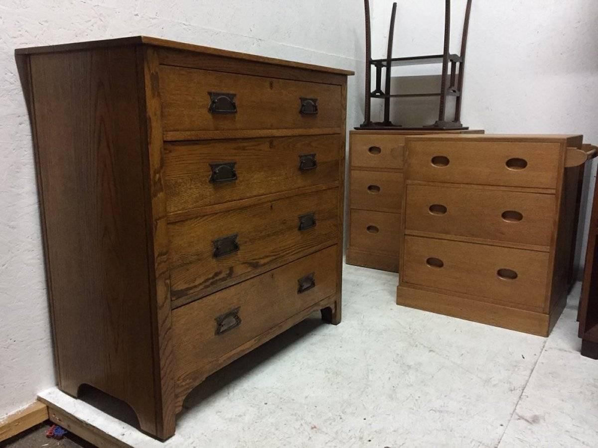 Harris Lebus an Arts and Crafts oak chest of two over three drawers with stylized floral details to the handles.