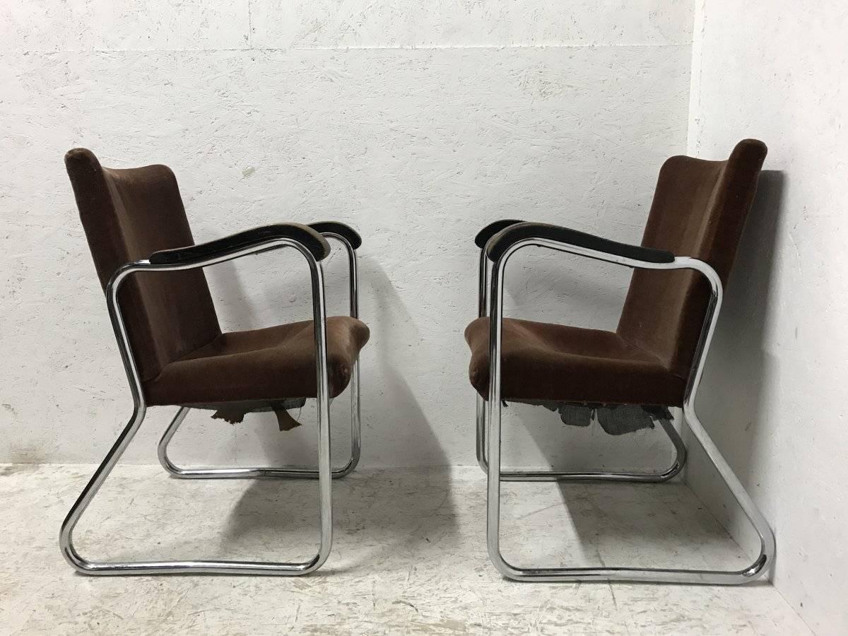 Thonet, an interesting pair of 1930s tubular steel armchairs in the Bauhaus style, each side is one flowing tube, organic shaped arms and conforming ebonized armrests which follow down the legs exaggerating shapes.