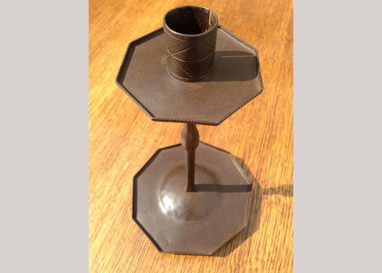 Designed by Ernest Gimson. A rare pair of Sheradised steel candlesticks, made by Alfred Bucknell, punched and chased with geometric design to the top, and a beautiful detail underneath the circular drip tray perfection even to the place that is