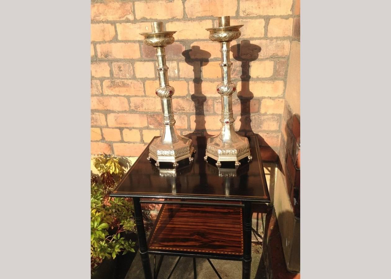 An impressive pair of tall Arts & Crafts silver plated candle sticks with semi-precious cabochons to the stem and to the central knop decorated with stylised floral detailing on eight lions paw feet.
In a medieval style with a strong Gothic Revival