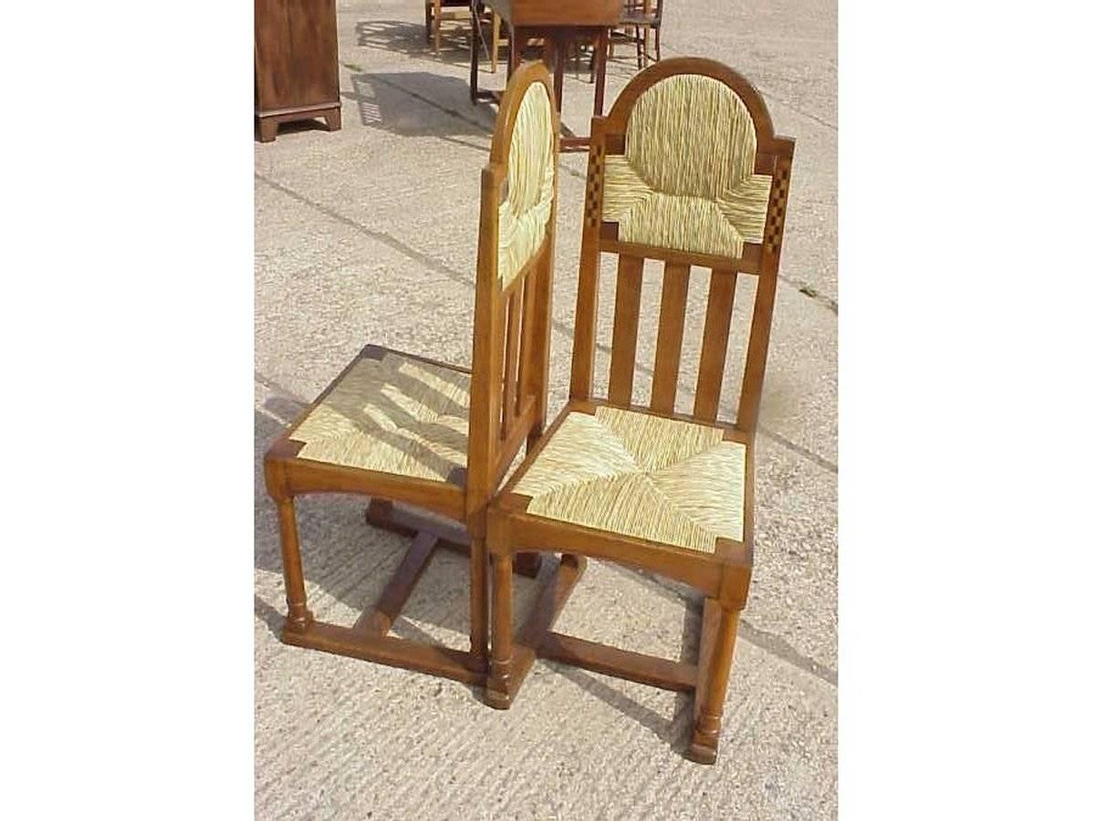 George Walton a attribué une paire de chaises en chêne de style Glasgow Arts and Crafts avec des incrustations d'ébène et de buis, une assise et un appui-tête en jonc, des pieds tournés et des brancards en forme de H au sol. 

 