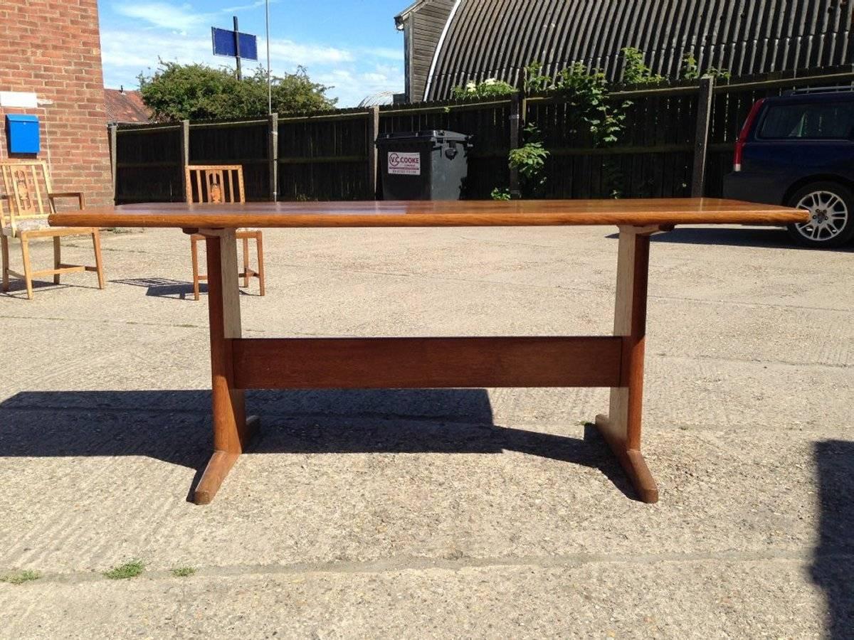 Peter Waals. An Arts & Crafts 6' figured oak refectory table, with a high stretcher uniting each end with chamfered through tenon joints. The shaped end supports resting on exaggerated tapering feet.
For similar examples see 'Modern British