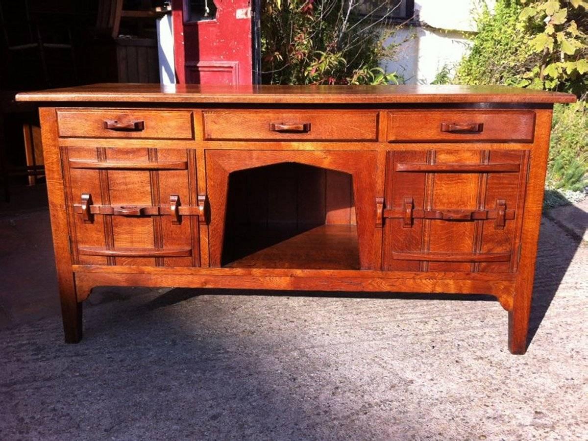 Acorn Industries attributed, an Arts & Crafts Yorkshire School craftsman made oak low sideboard with hand-carved handles and hand-carved through latch style handles to the lower doors.