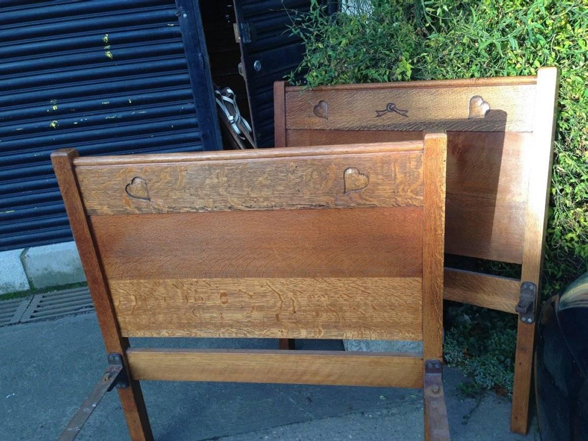 Early 20th Century Heals, Near Pair of Arts & Crafts Single Oak 3 Foot Wide Beds with Carved Hearts For Sale