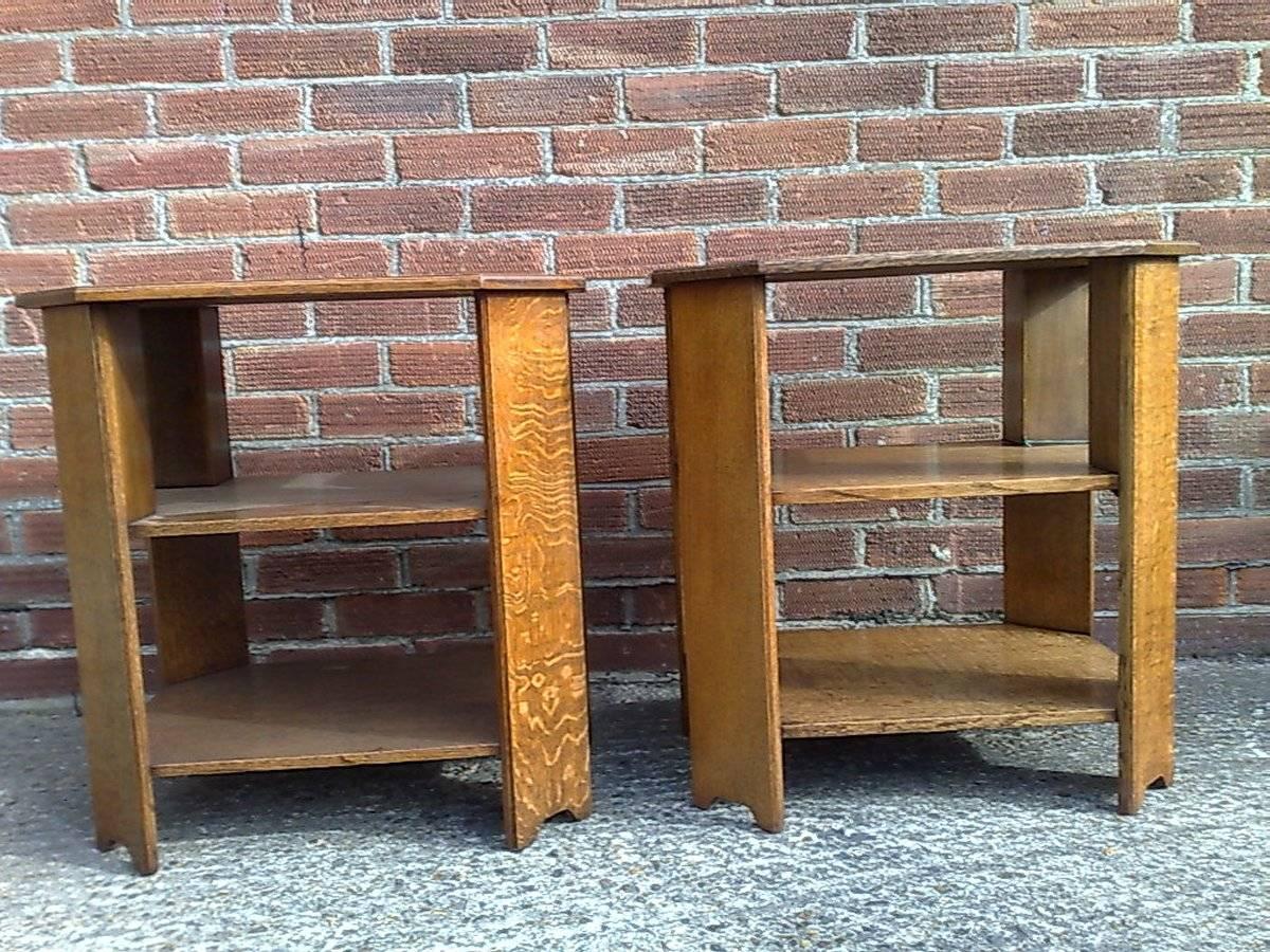 Heals. A pair of Arts and Crafts oak end or book tables with three tiers and canted corners with nice figuring of the grain.