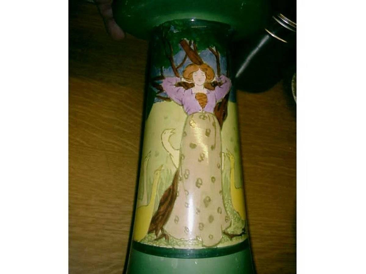 A hand-painted tulip style vase designed by Edward Spencer with a Pre-Raphaelite Maiden amongst Geese. Small chip to the base.