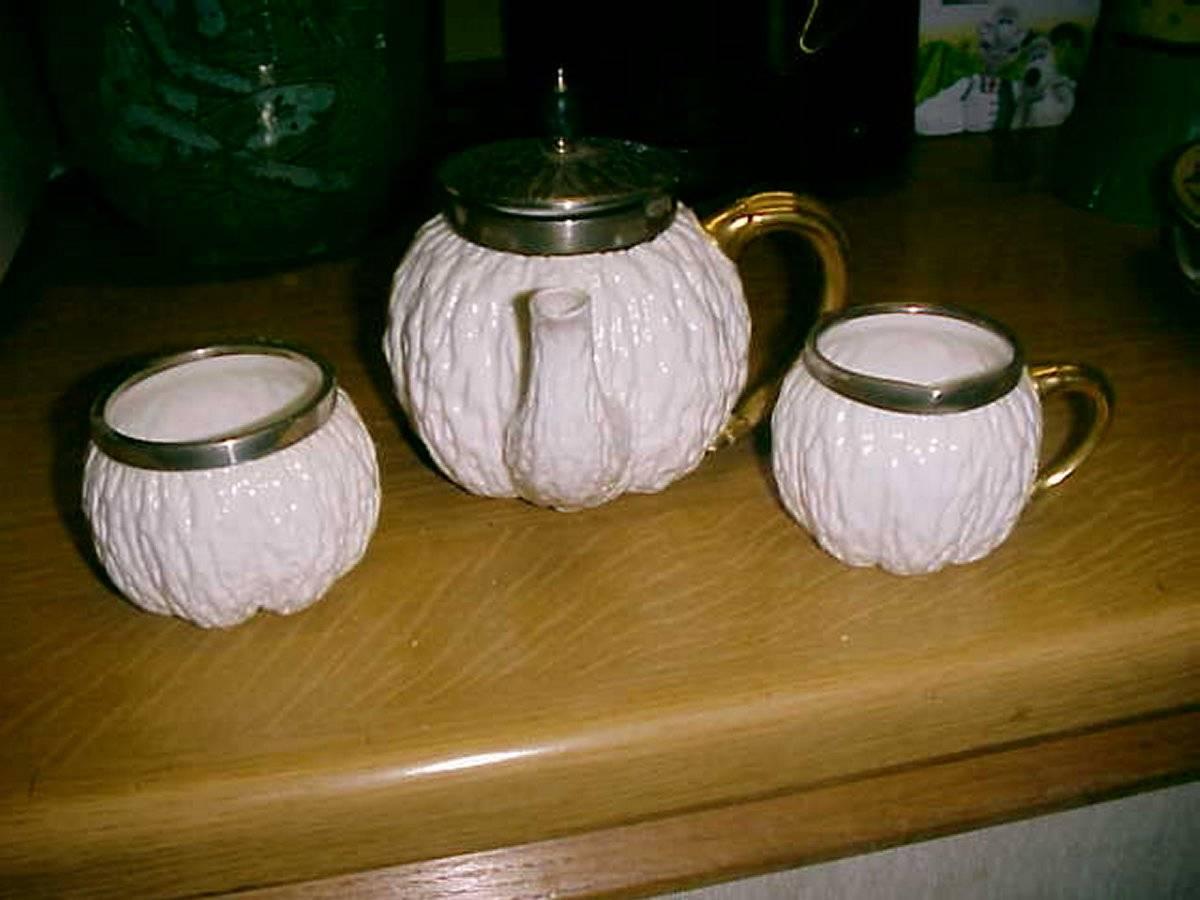 Christopher dresser attr A three-piece tea set made by Coalport for Hukin and Heath, with gilt handles and gilt silver mounts. Birmingham date code for 1893. Silver stamped JTH and JHM for John Thomas Heath and John Hartshorne Middleton of Heath and