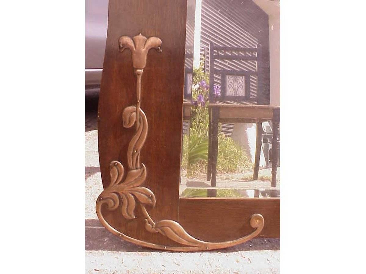 Arts and Crafts An Arts & Crafts Shaped Oak Bevelled Mirror with Stylised Floral Copper Details