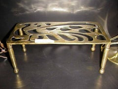 An Aesthetic Movement Brass Trivet with Peacock Fret Work, on Turned Legs