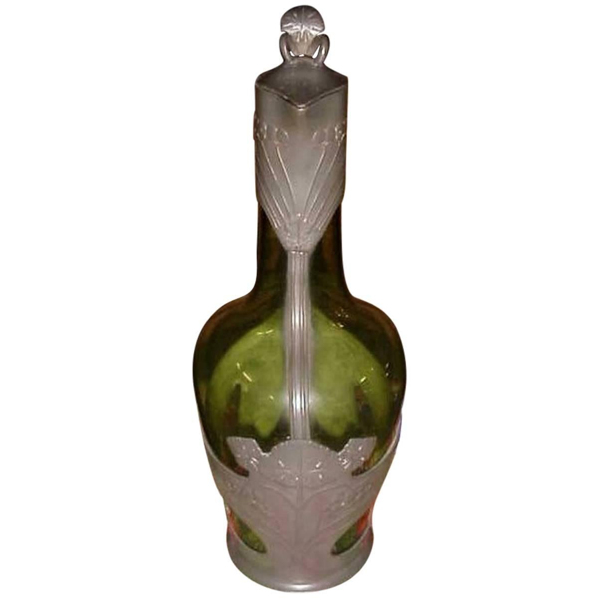 Orivit. An Art Nouveau pewter and green glass decanter. Design Number 1211. 
Unmarked but an identical version with stamped Orivit marks was illustrated in the Christies Art Nouveau sale 12 October 2004.